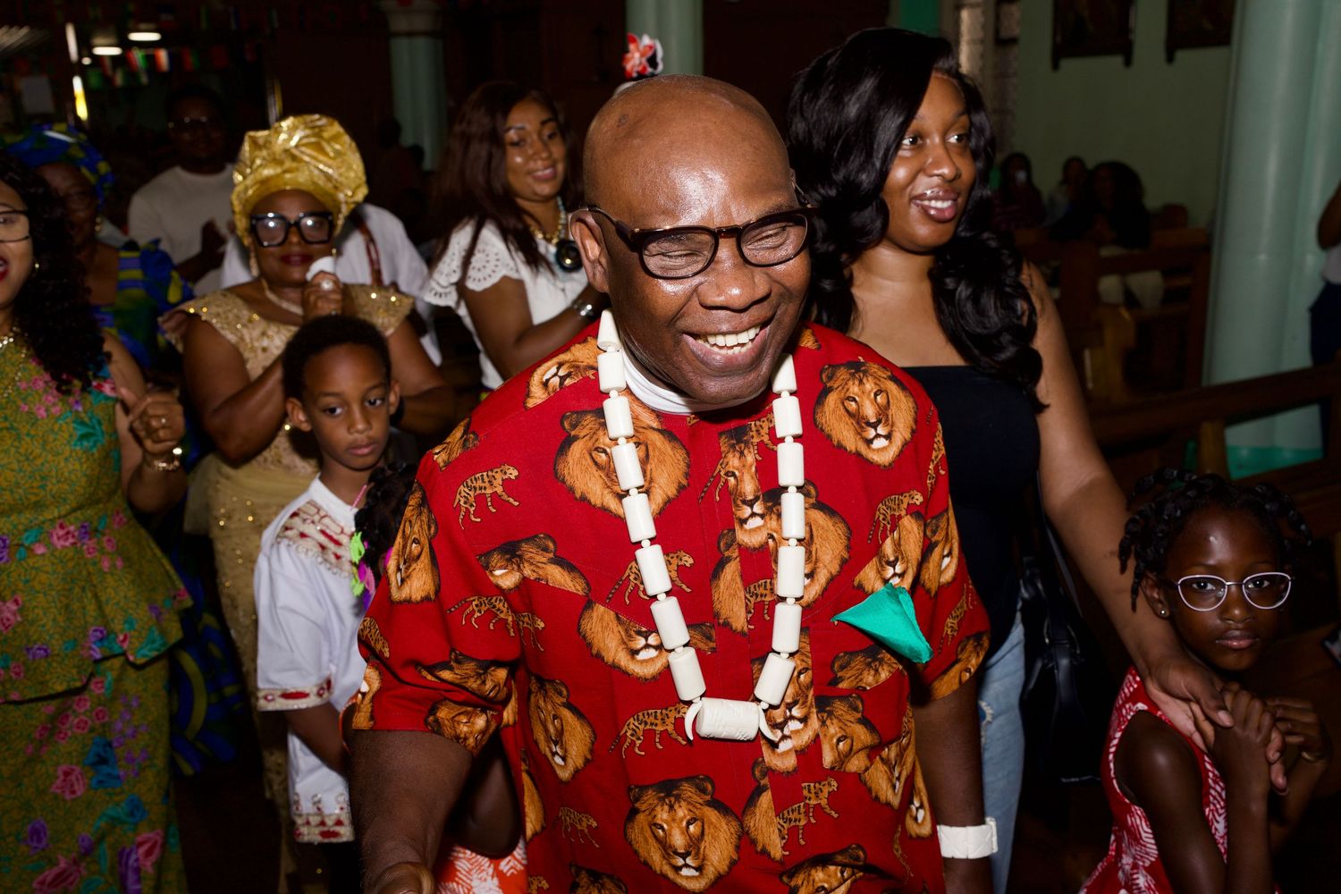 Man in traditional African attire smiling during church Culture Day procession by ARIETA Studios