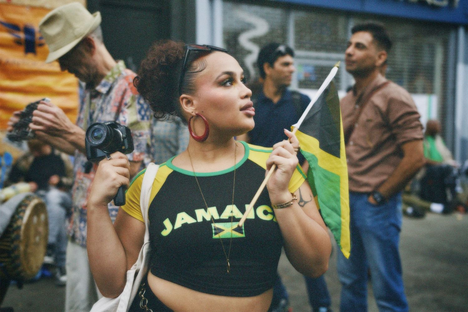 Vibrant outdoor street portrait of a woman smiling in a festival crowd setting.