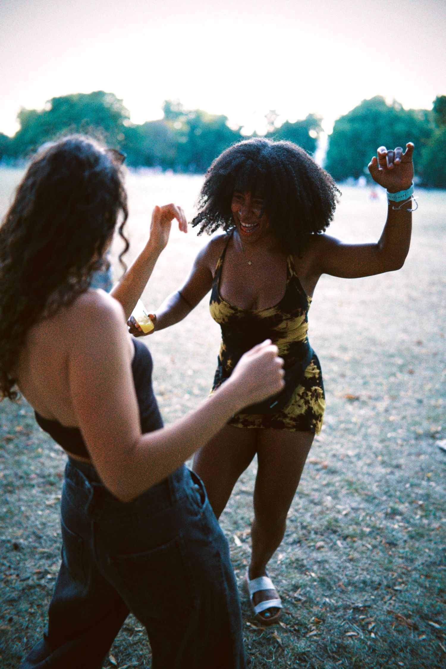 Two women dancing outdoors at a London summer community event captured by ARIETA Studios.