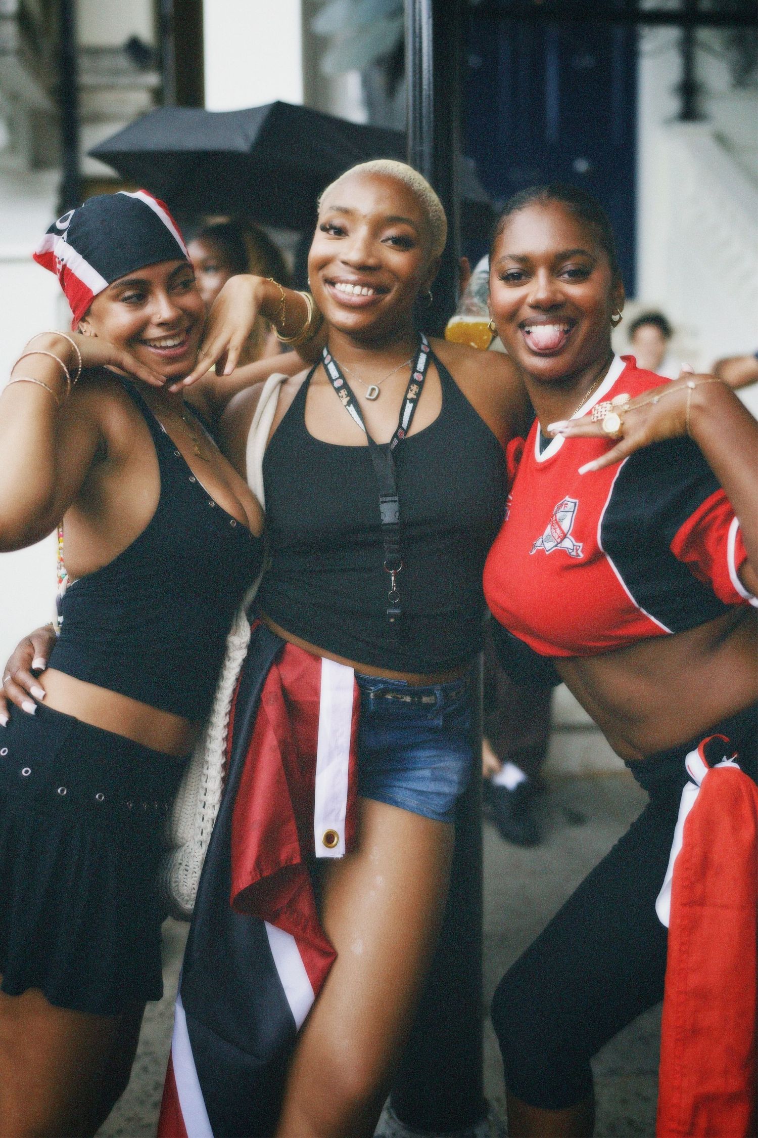 Candid street portrait of three women laughing and posing together in Notting Hill.