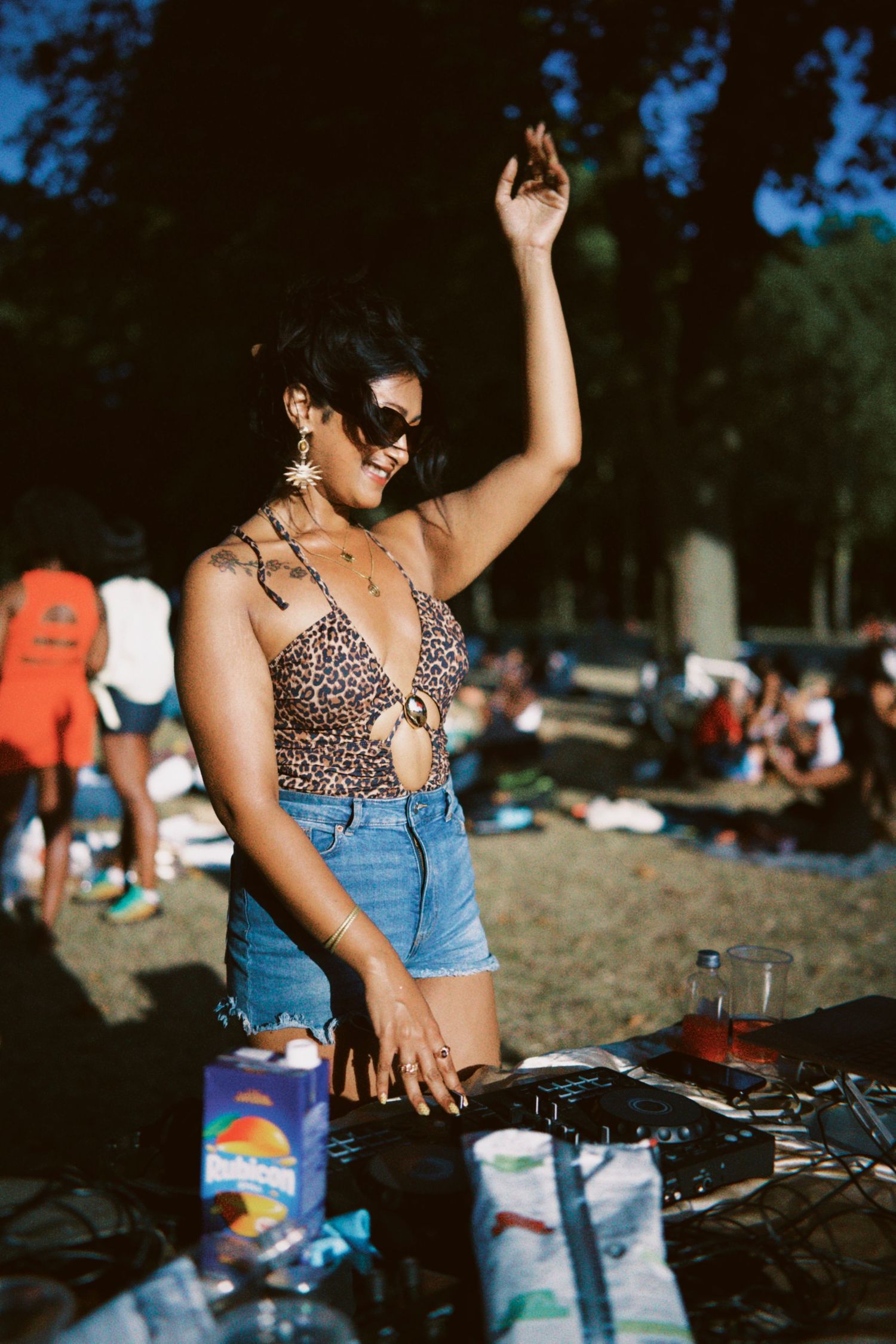 Dj Sarpila Sounds, a woman dancing outdoors at Mango in the park event captured by ARIETA Studios in London.