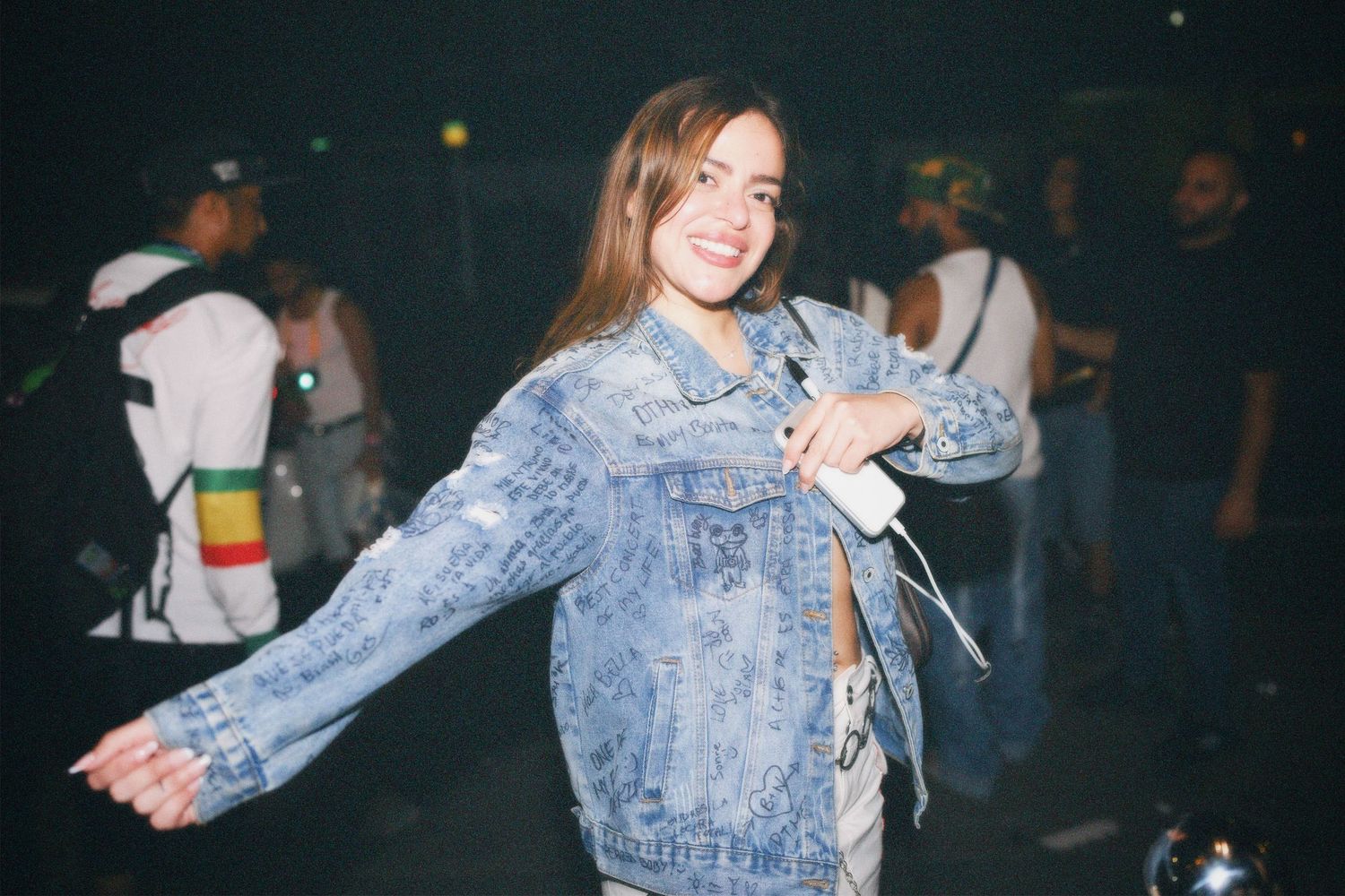 Woman smiling in denim jacket at night event captured by ARIETA Studios.