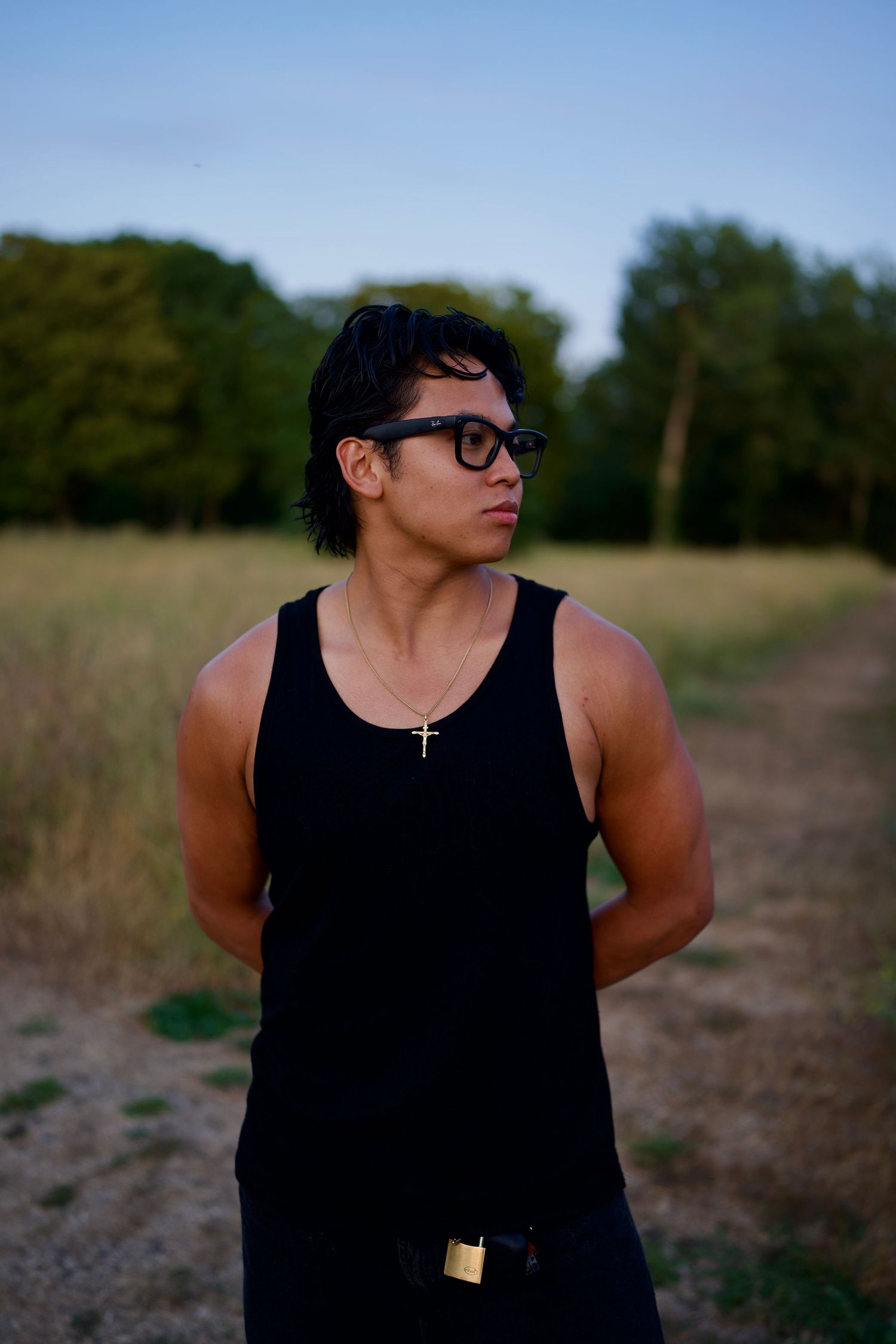 Natural light portrait of a Alastair standing outdoors against a wooded tree line, founder of Arieta Studios