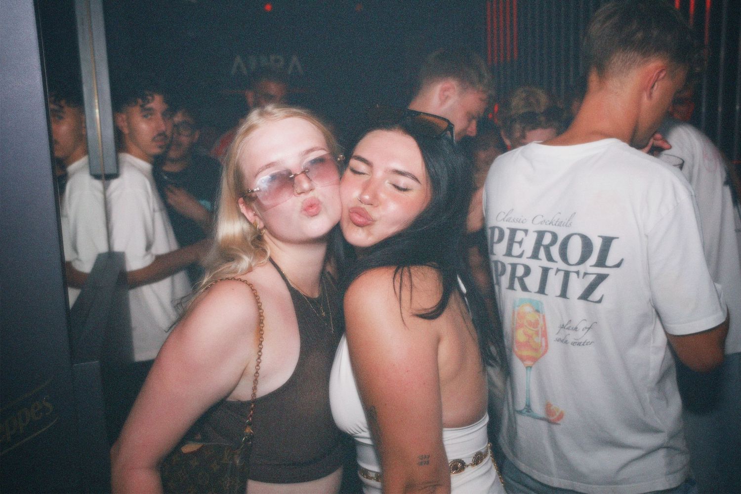 Two women posing cheek-to-cheek. / Dos chicas posando juntas en la fiesta.