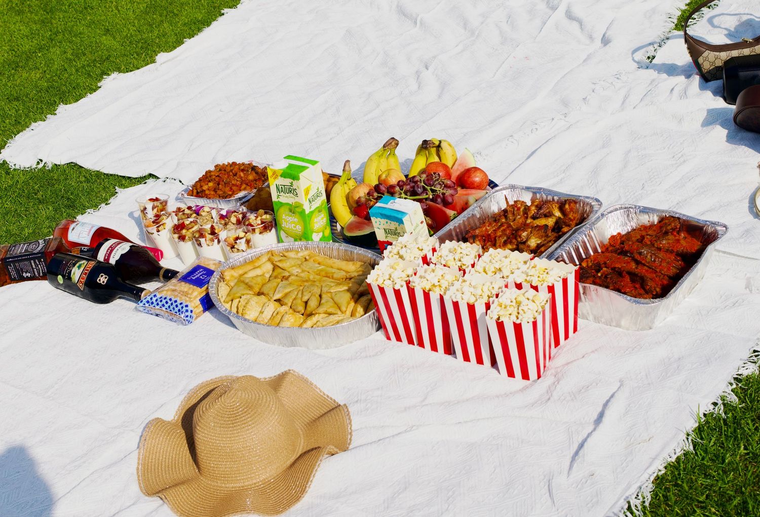 Outdoor picnic setup with food spread on blanket for garden party by ARIETA Studios.