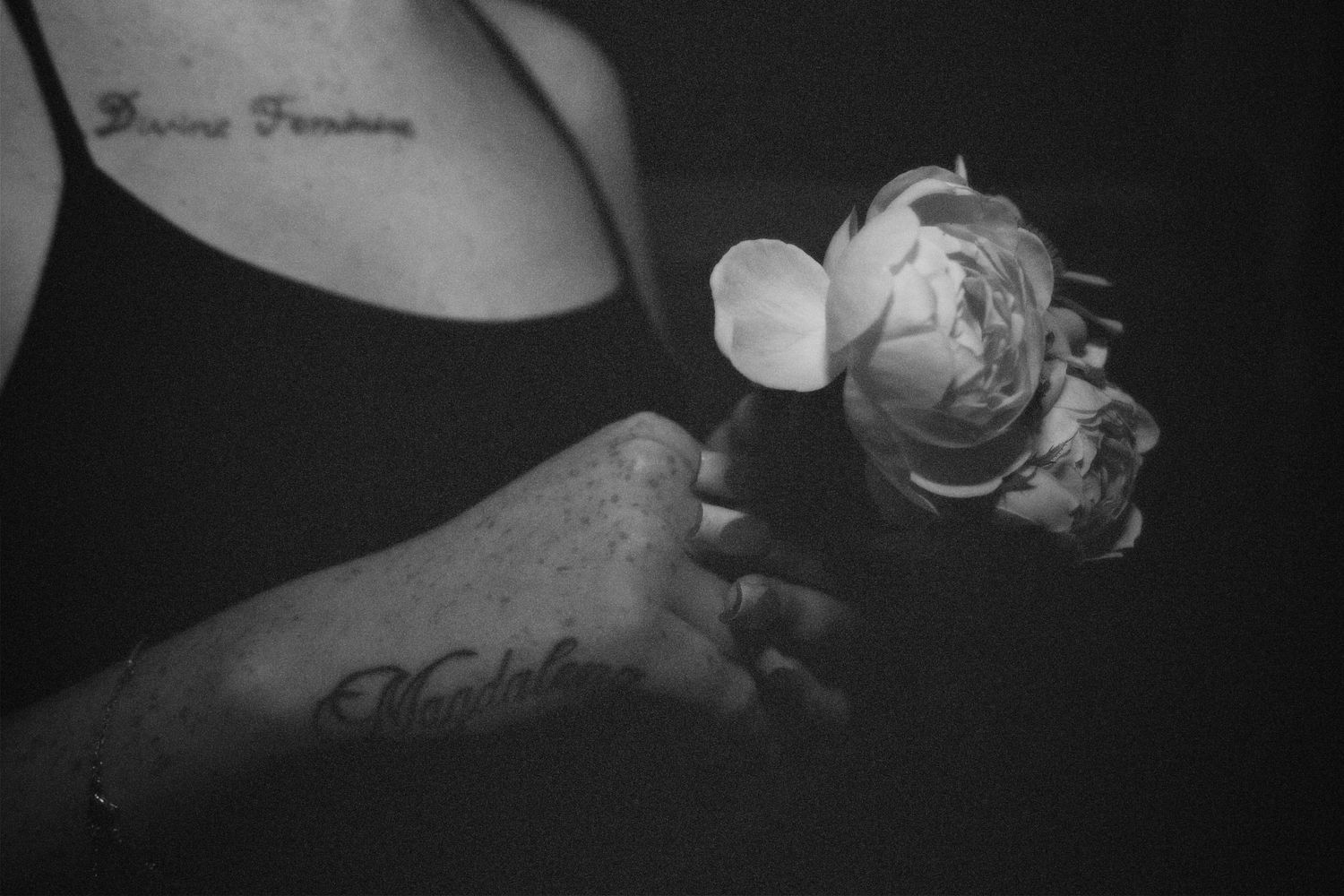 Black-and-white close-up of a woman's hands holding white flowers.