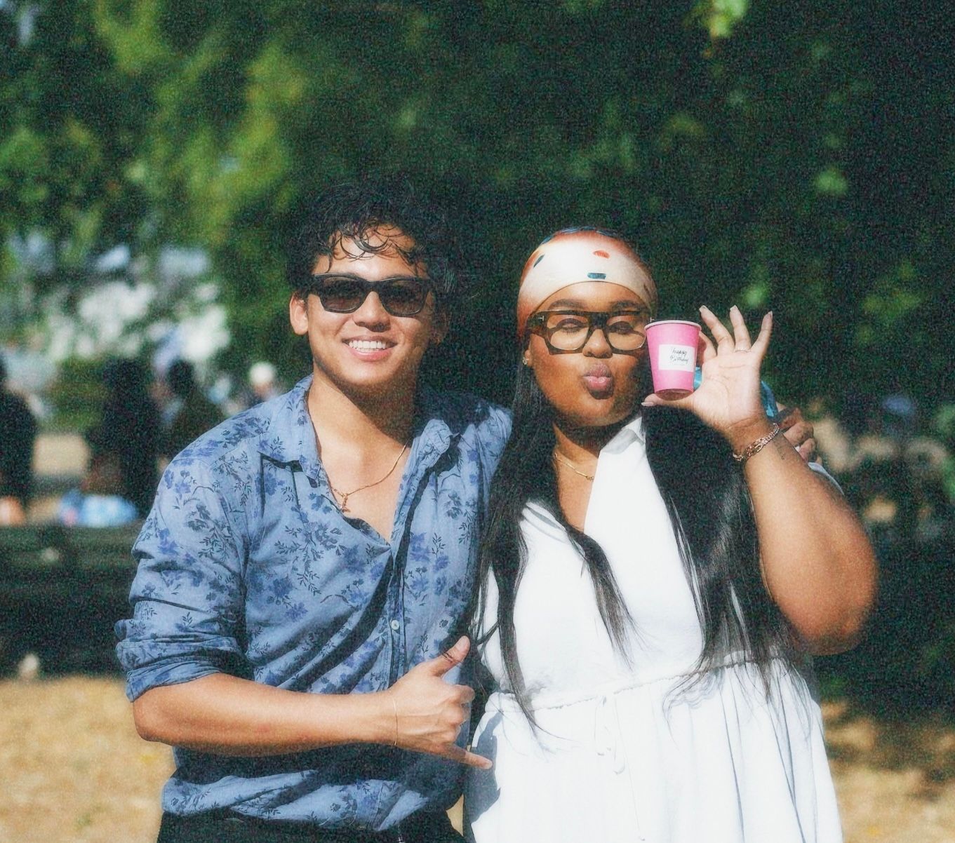 The photographer, Alastair and celebrant Chantelle, two friends posing outdoors and making peace signs at the camera.