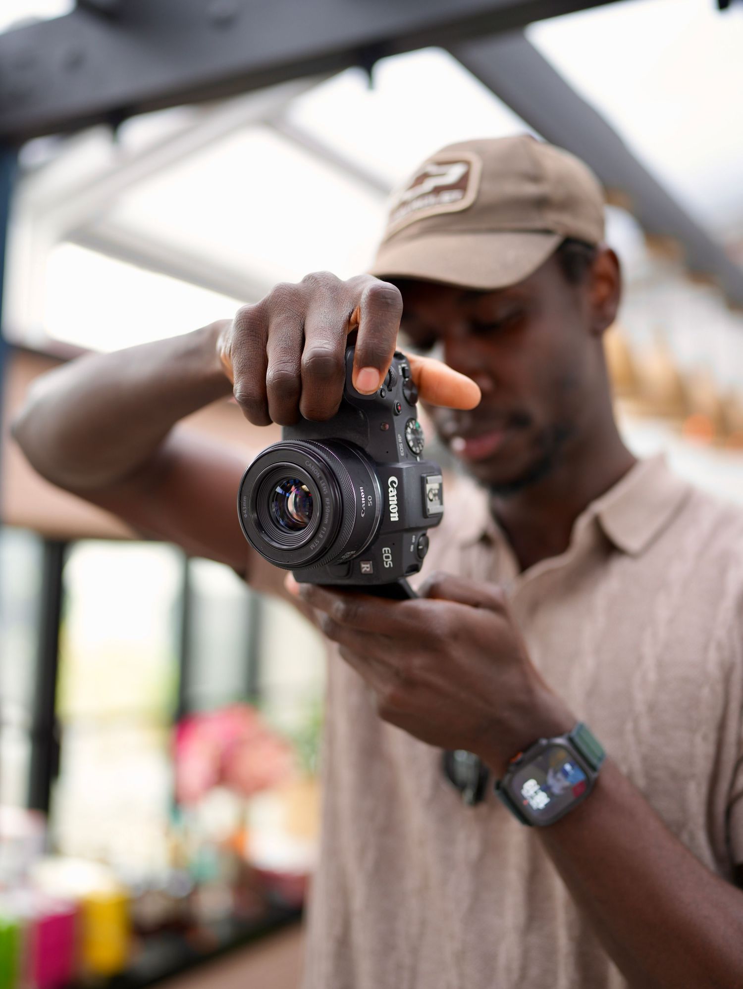 Close-up of a photographer adjusting a mirrorless camera at an outdoor media shoot.