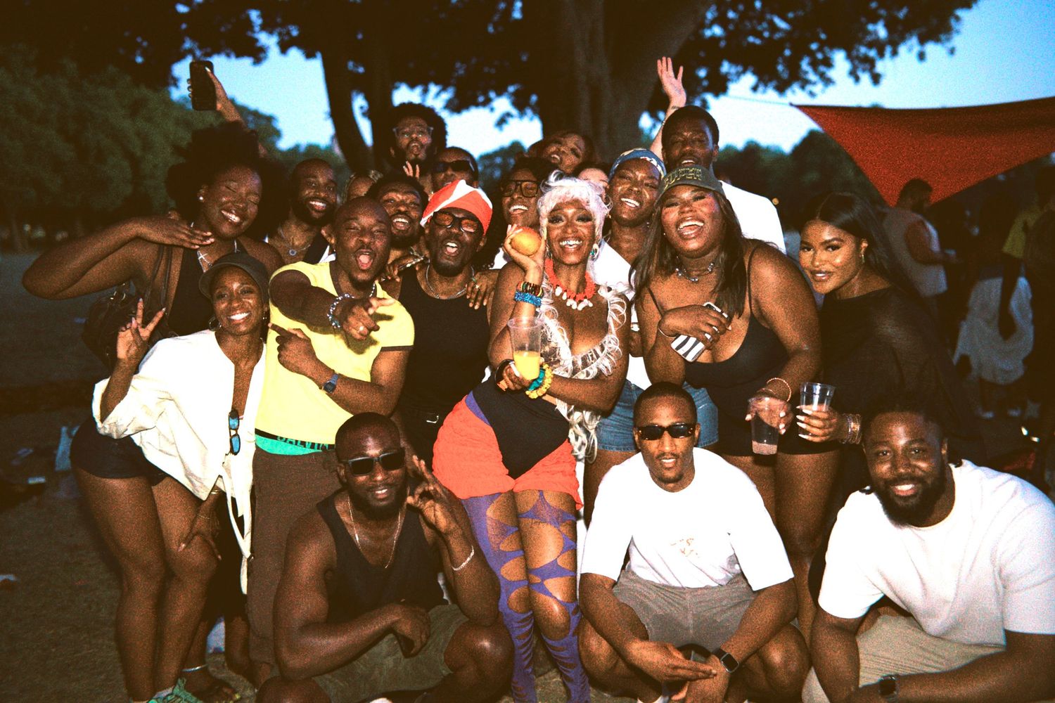Group of friends posing together outdoors at daytime party by ARIETA Studios.