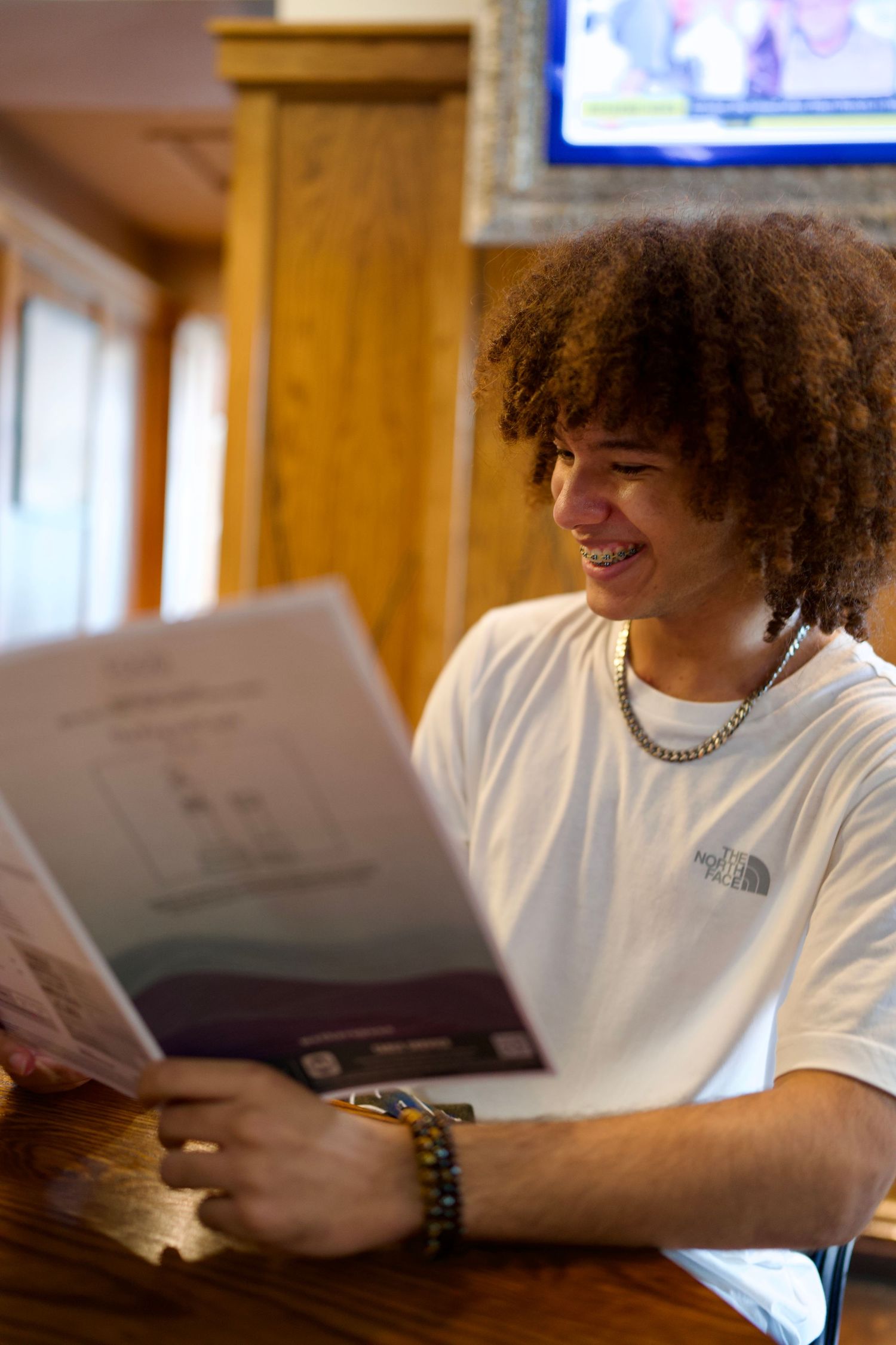 Young man smiling while checking the show details inside the pub.