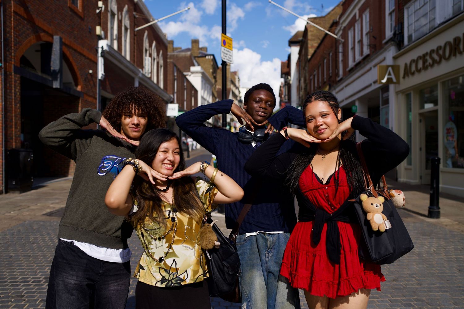 Candid street portrait in Windsor of a sister and friends striking high-energy editorial poses before watching Heathers The Musical.
