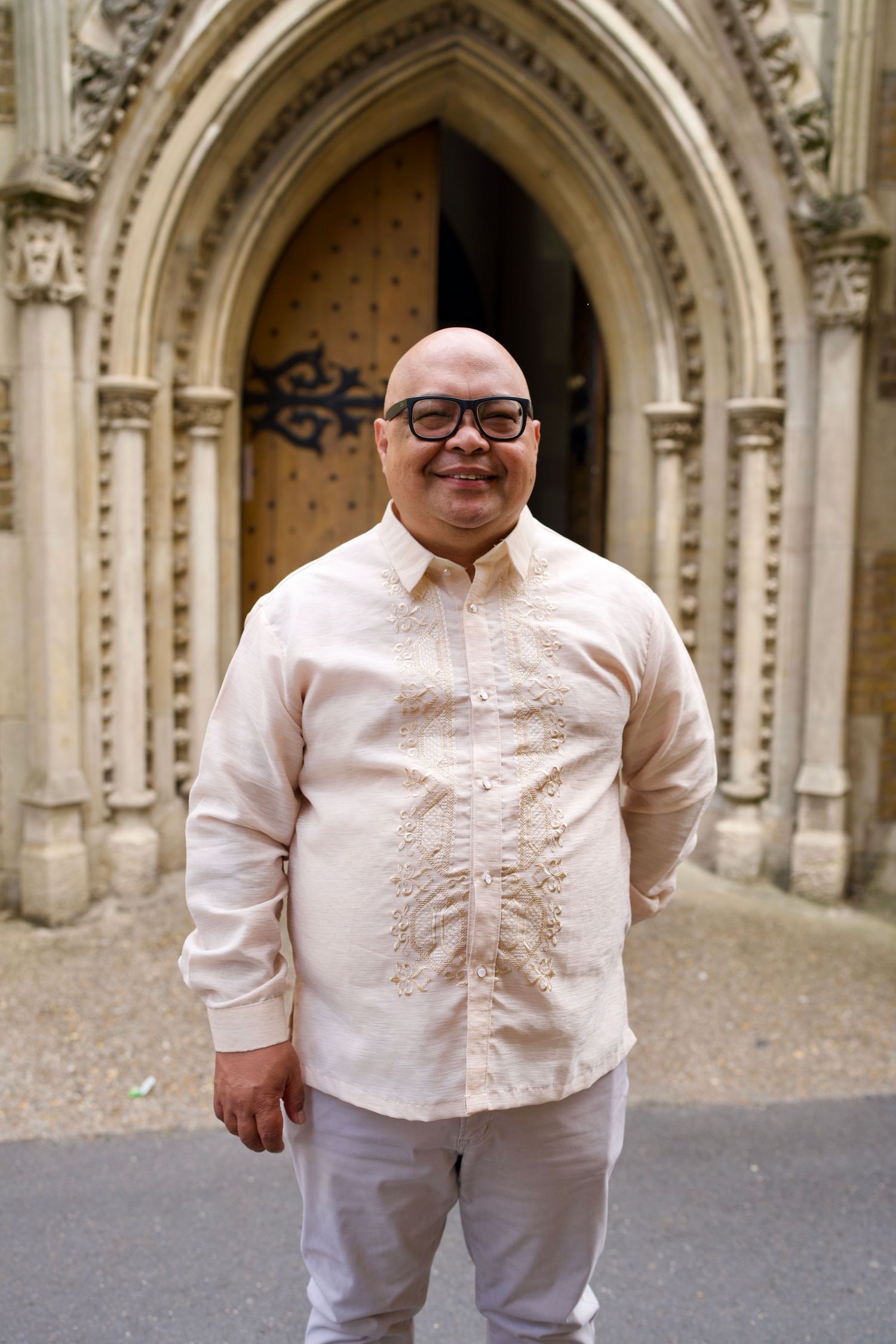 Portrait of man in traditional Barong Tagalog outside historic church by ARIETA Studios.