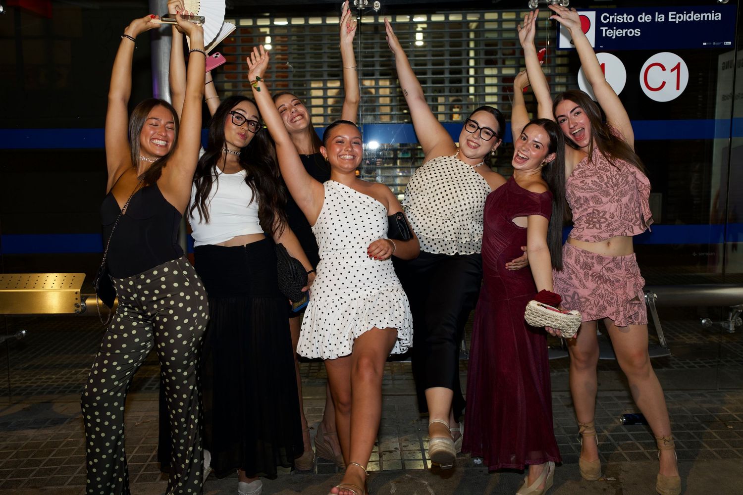 Group of women celebrating with arms raised at Feria de Málaga / Grupo de mujeres celebrando con brazos arriba en Feria de Málaga