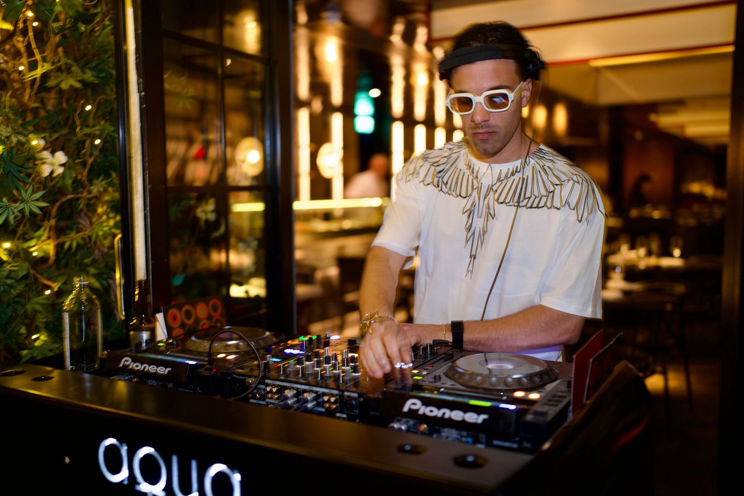 DJ mixing tracks behind decks at luxury London venue captured by ARIETA Studios.
