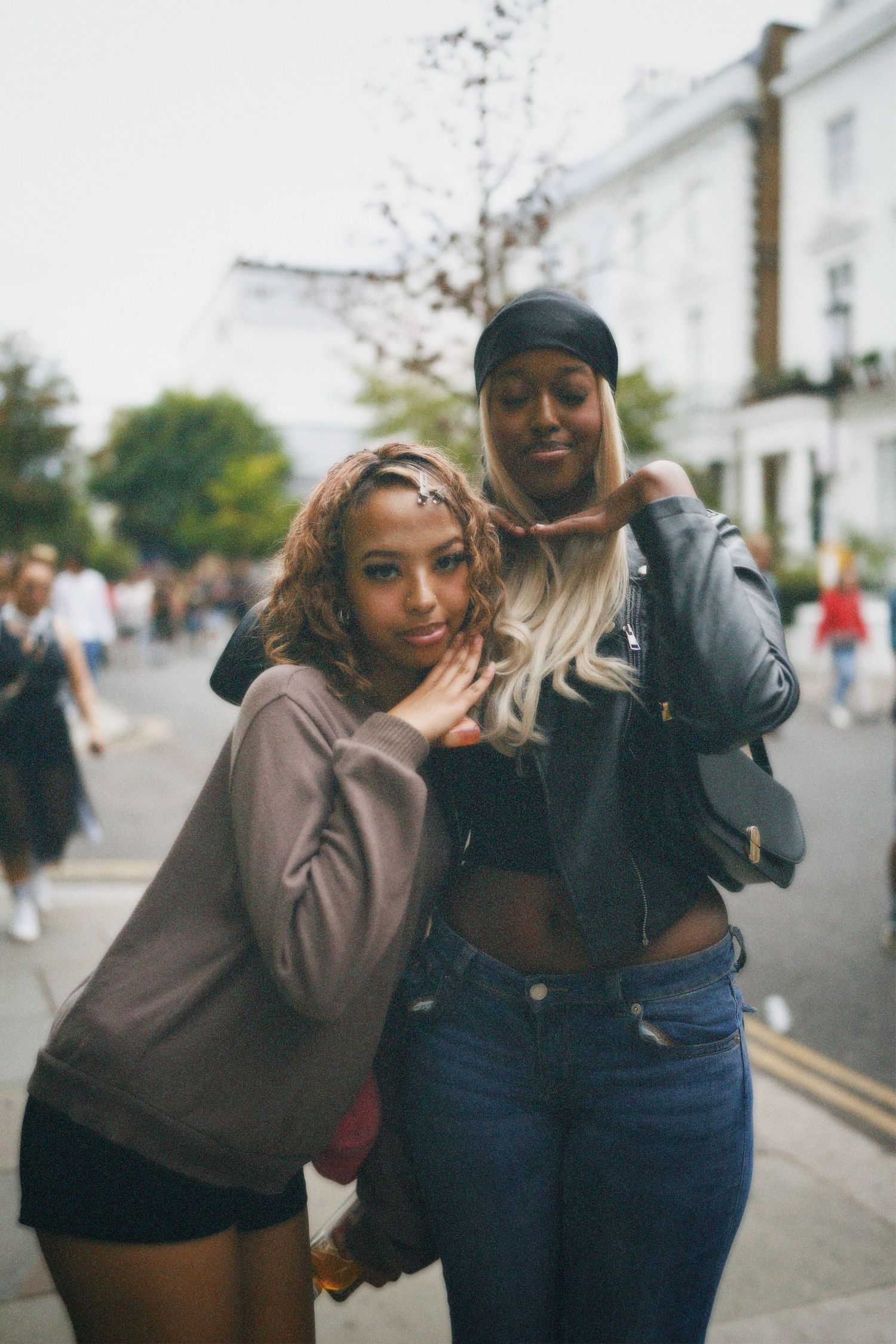 Street portrait of two women smiling together on a residential street during Carnival.