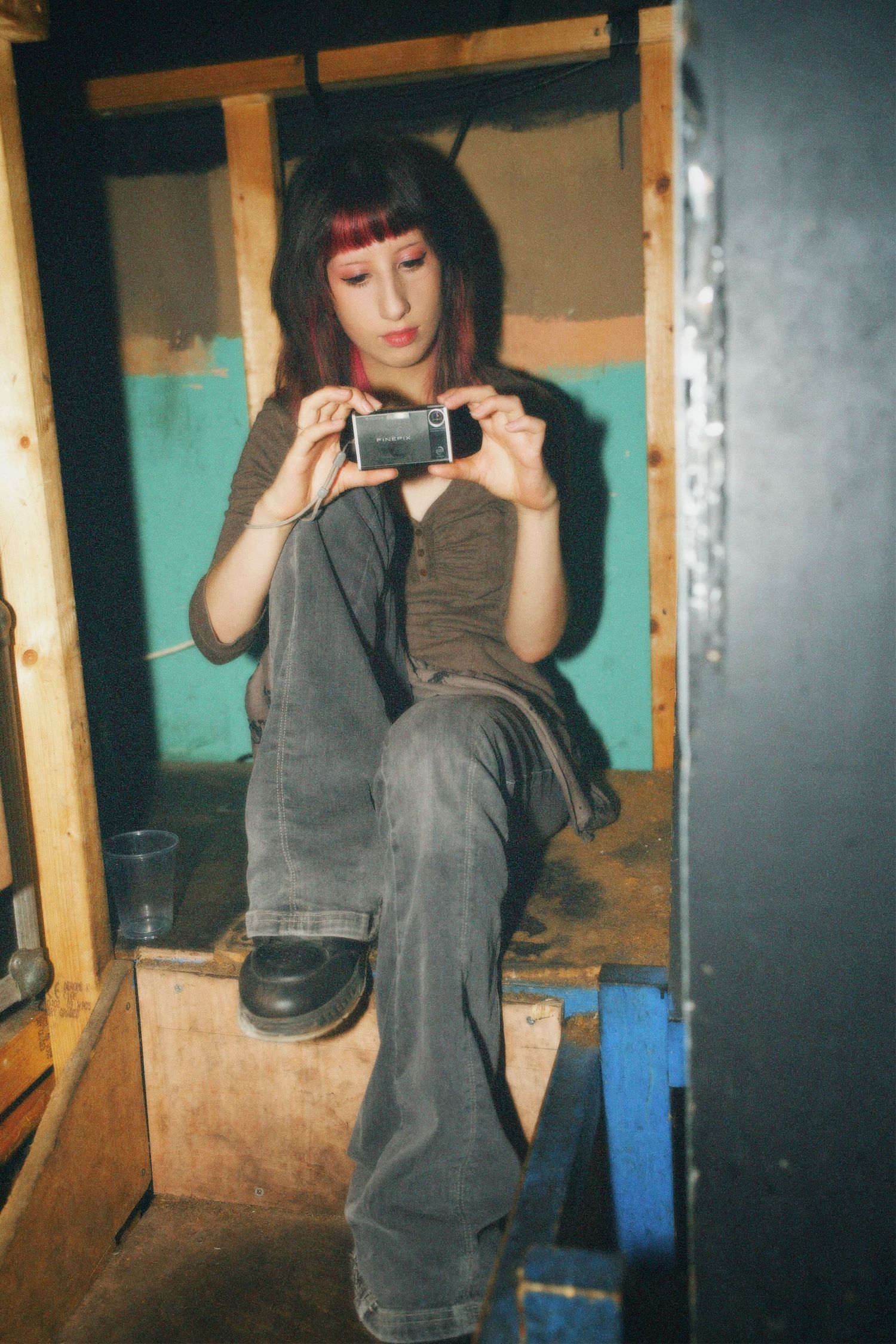 Woman taking a photo with a compact digital camera during the Fashion For Future sustainable fashion event at The Jago