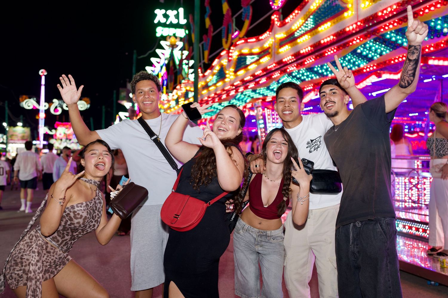 Friends smiling at night at Feria de Málaga by Arieta Studios / Amigos sonriendo de noche en la Feria de Málaga por Arieta Studios.