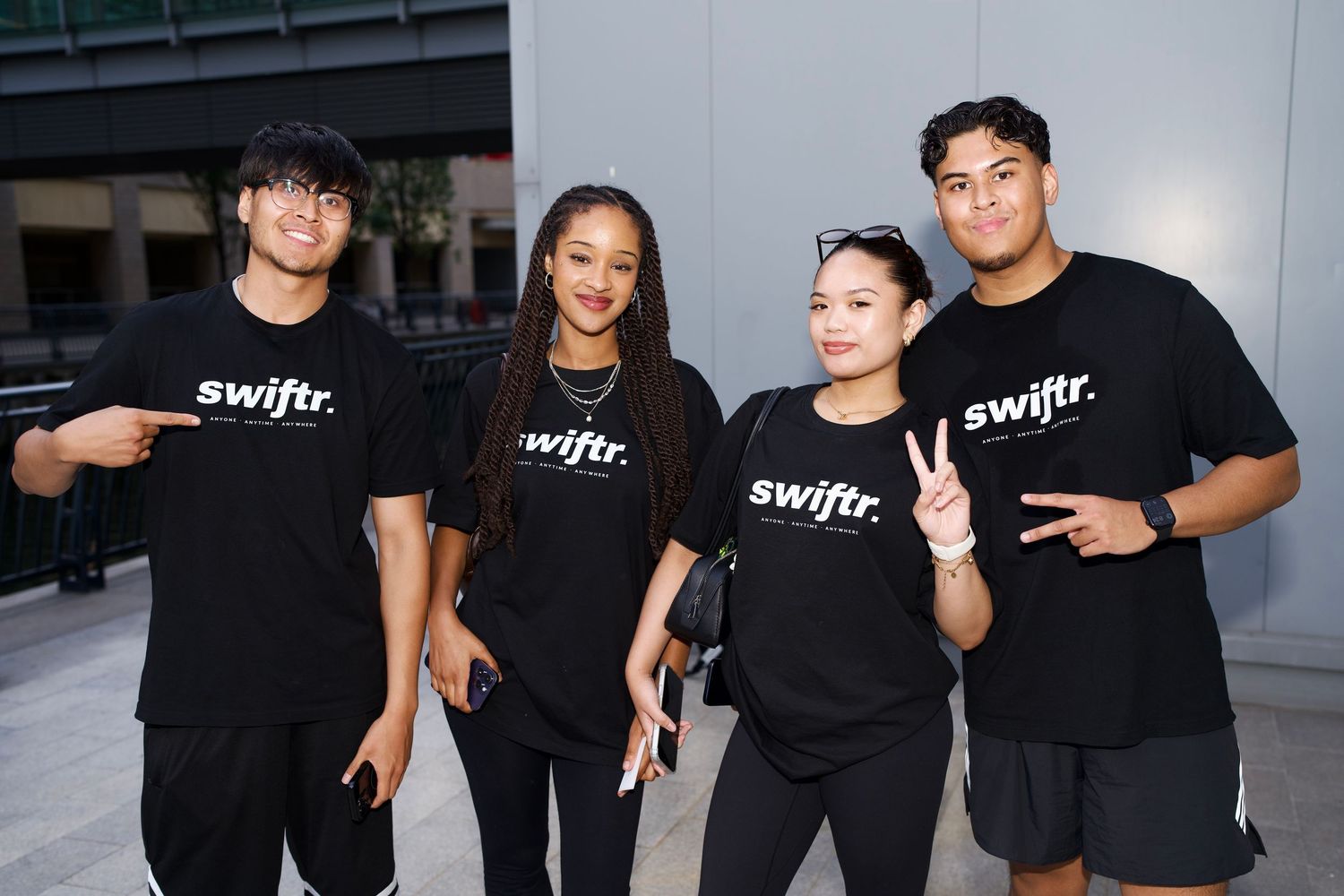 Group of four friends in black swiftr t-shirts posing outdoors captured by ARIETA Studios.