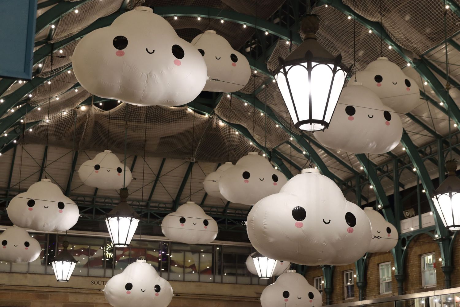 Creative high-angle shot of decorative cloud lights hanging in a London market venue, captured by artist ARIETA Studios.