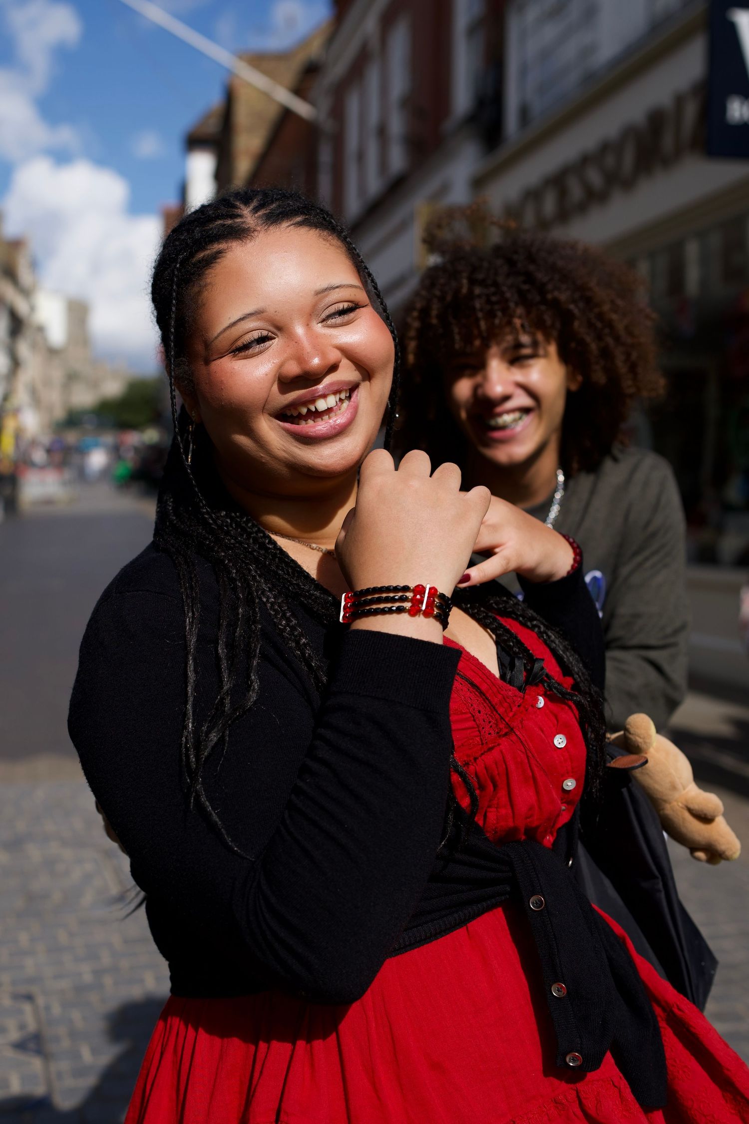 Two friends laughing together outdoors during a day trip in Windsor.