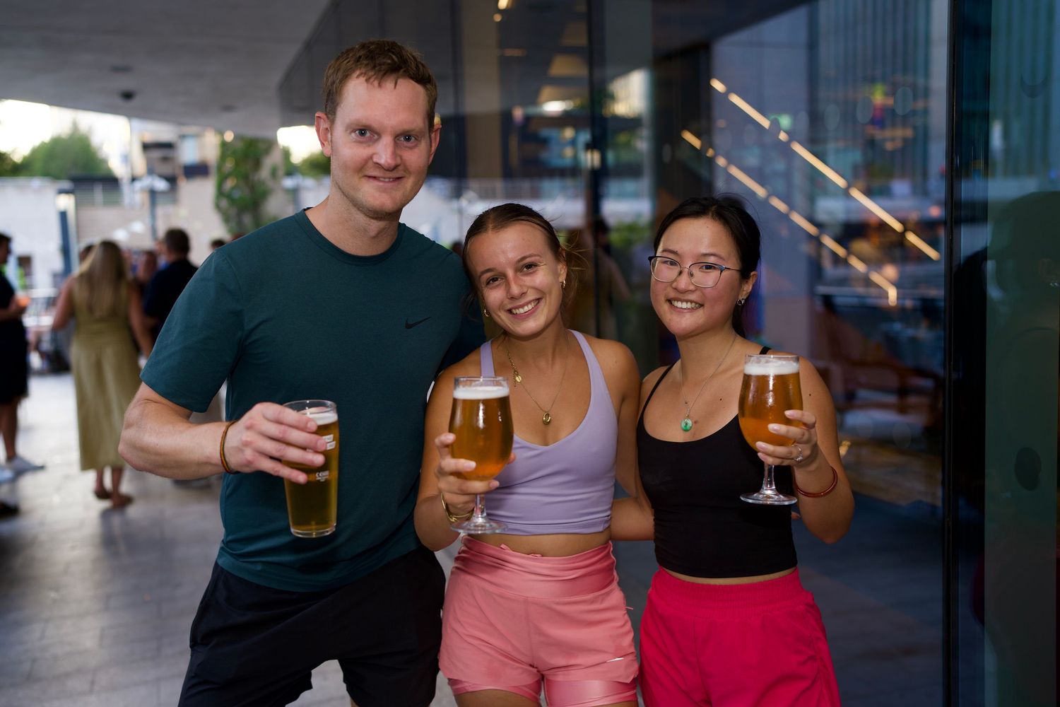 Three runners posing with cold drinks after completing a workout session by ARIETA Studios.