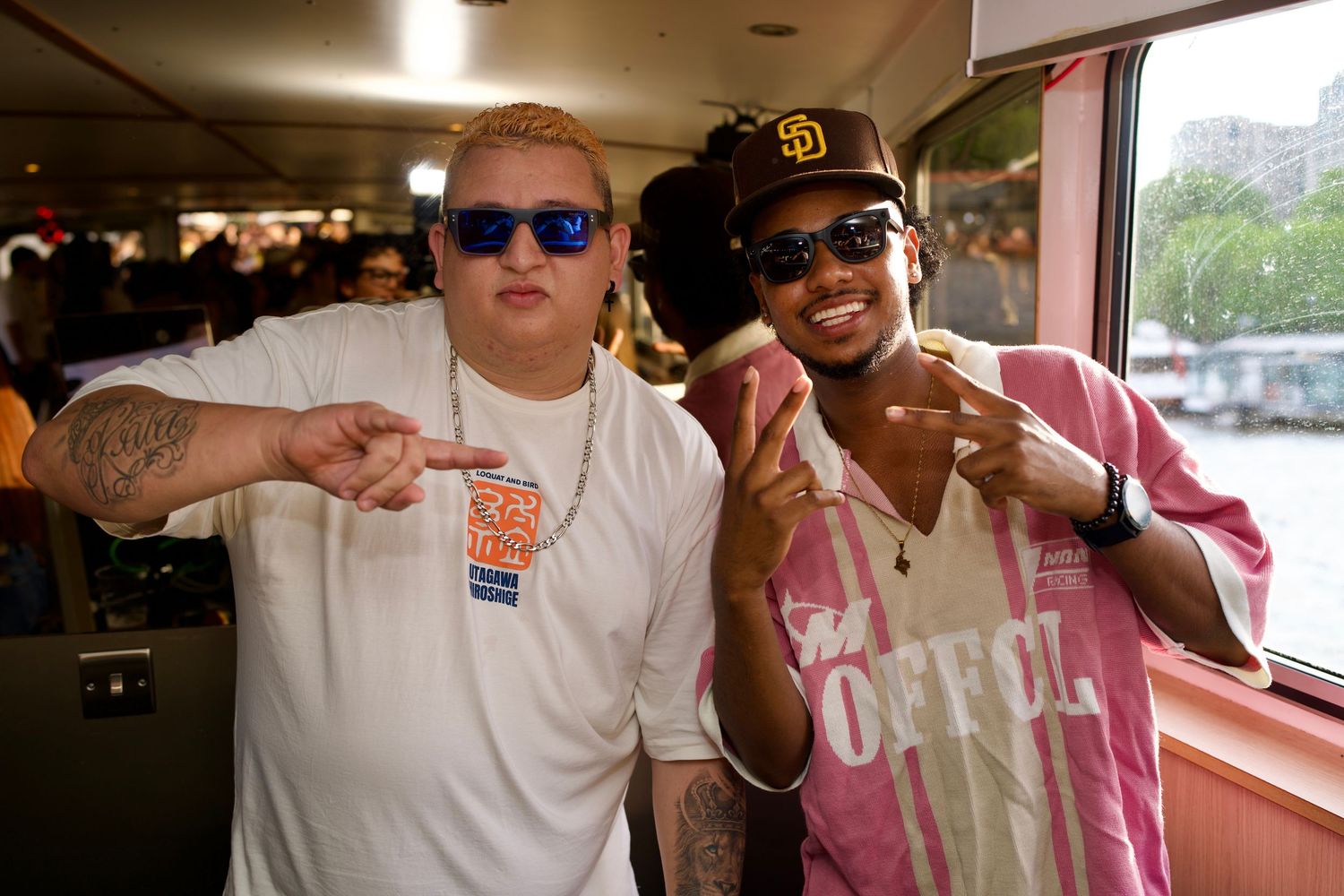 Two DJs posing and throwing peace signs on boat party by ARIETA Studios.