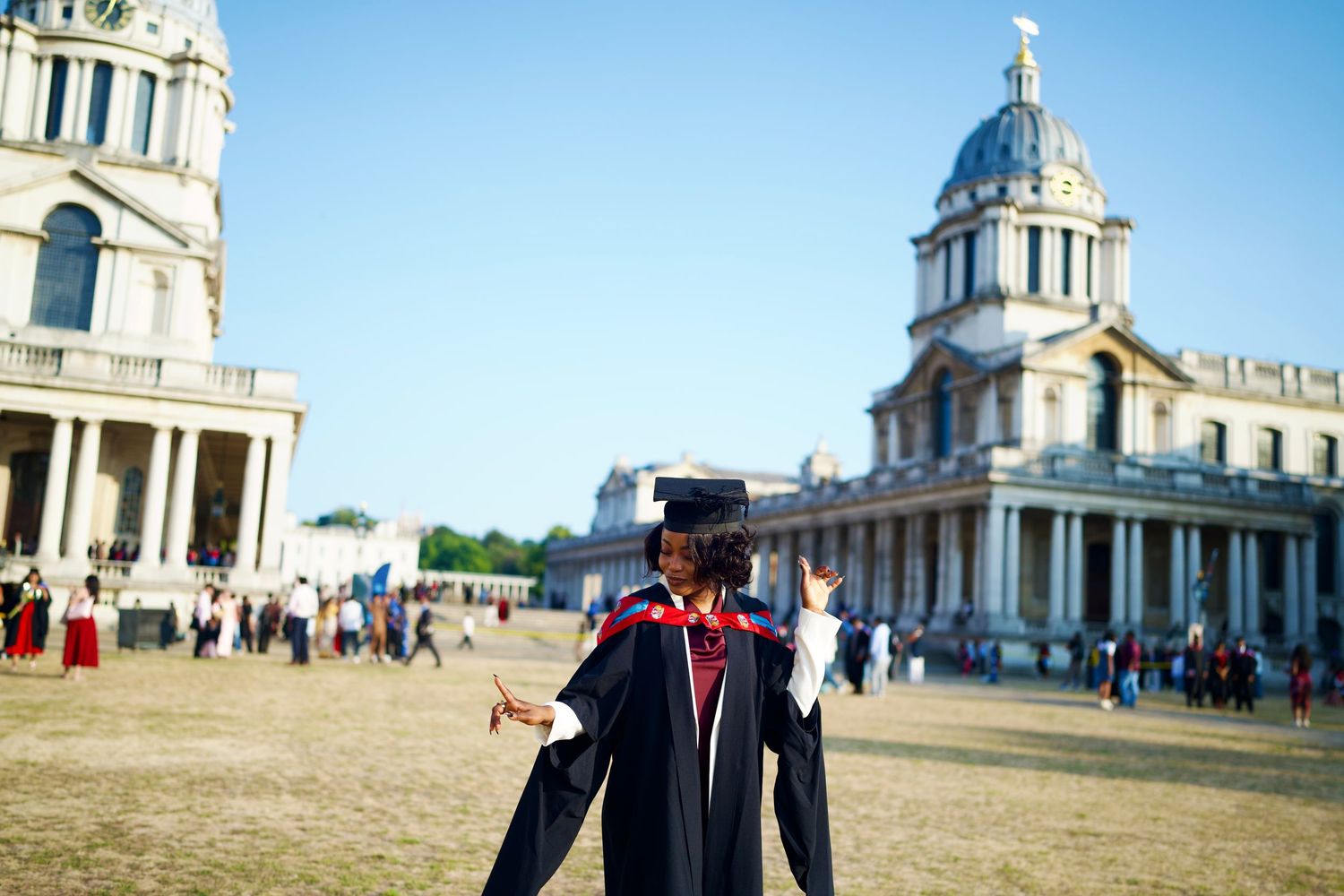 Graduate posing in cap and gown at Old Royal Naval College Greenwich for ARIETA Studios editorial.