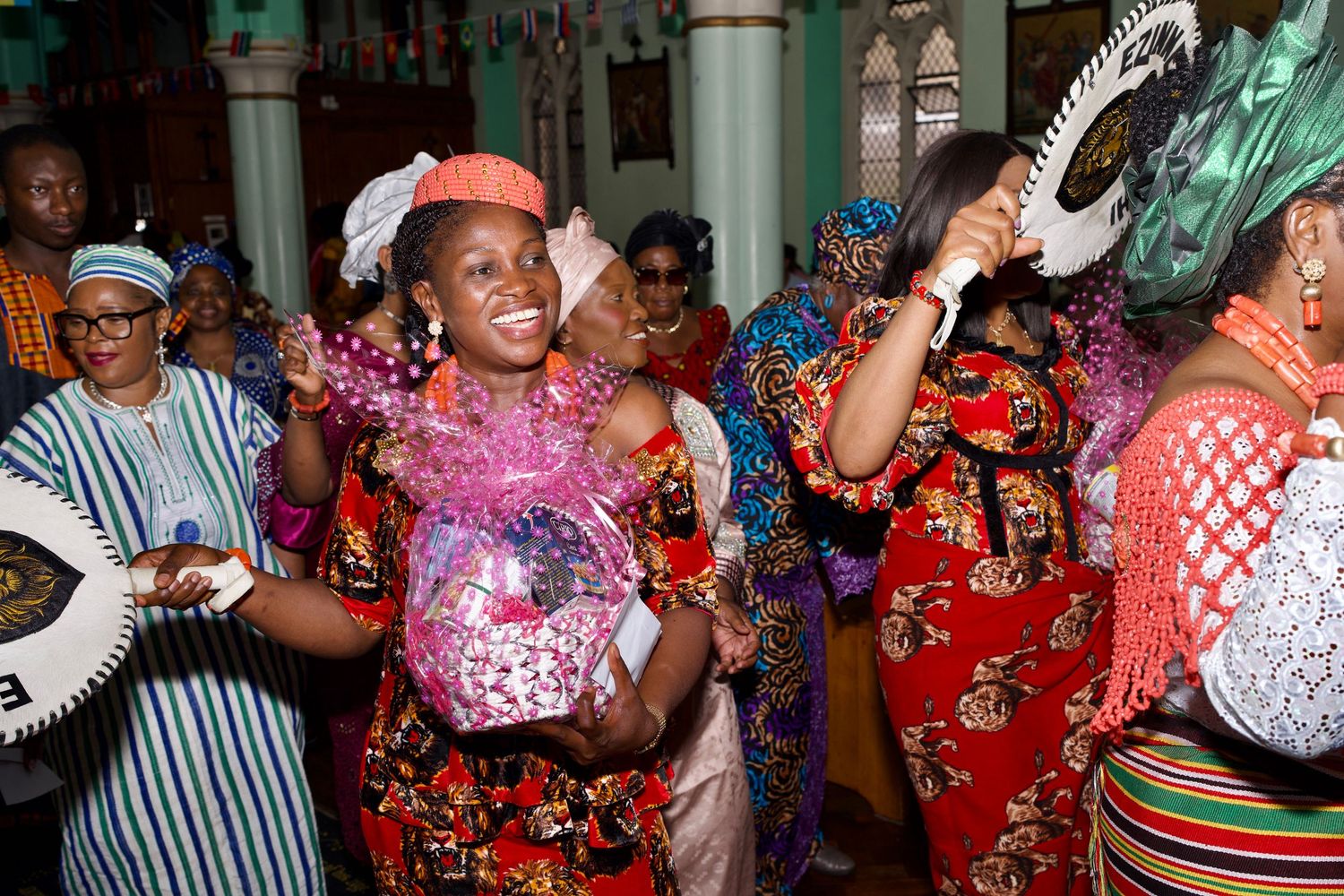 Women dancing in traditional attire carrying gift baskets during Culture Day by ARIETA Studios.