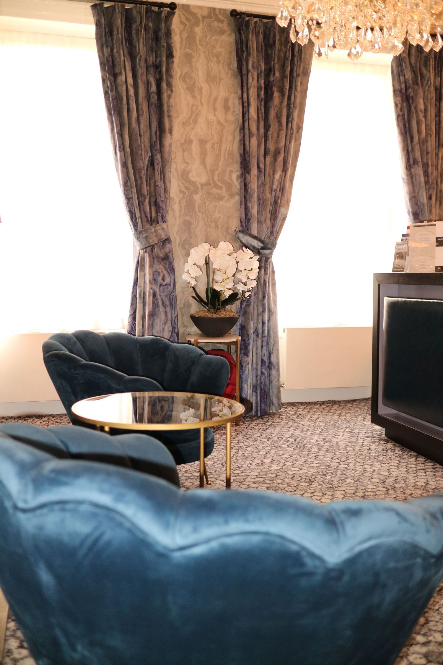 Elegant interior photography of a luxury lounge space with plush blue seating, shot by venue studio ARIETA Studios.
