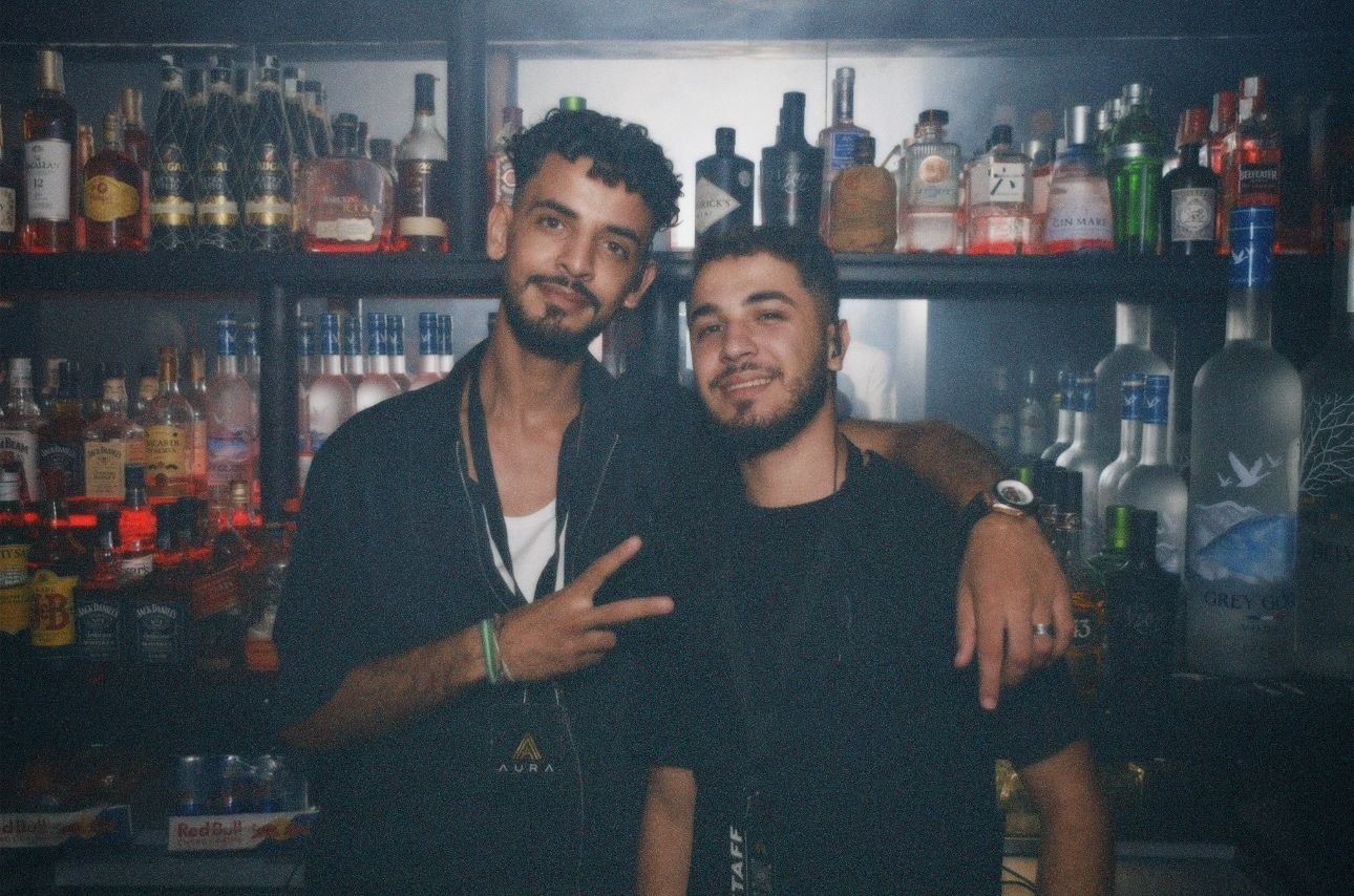 Staff members posing at the bar. / Personal posando sonrientes tras la barra del club.