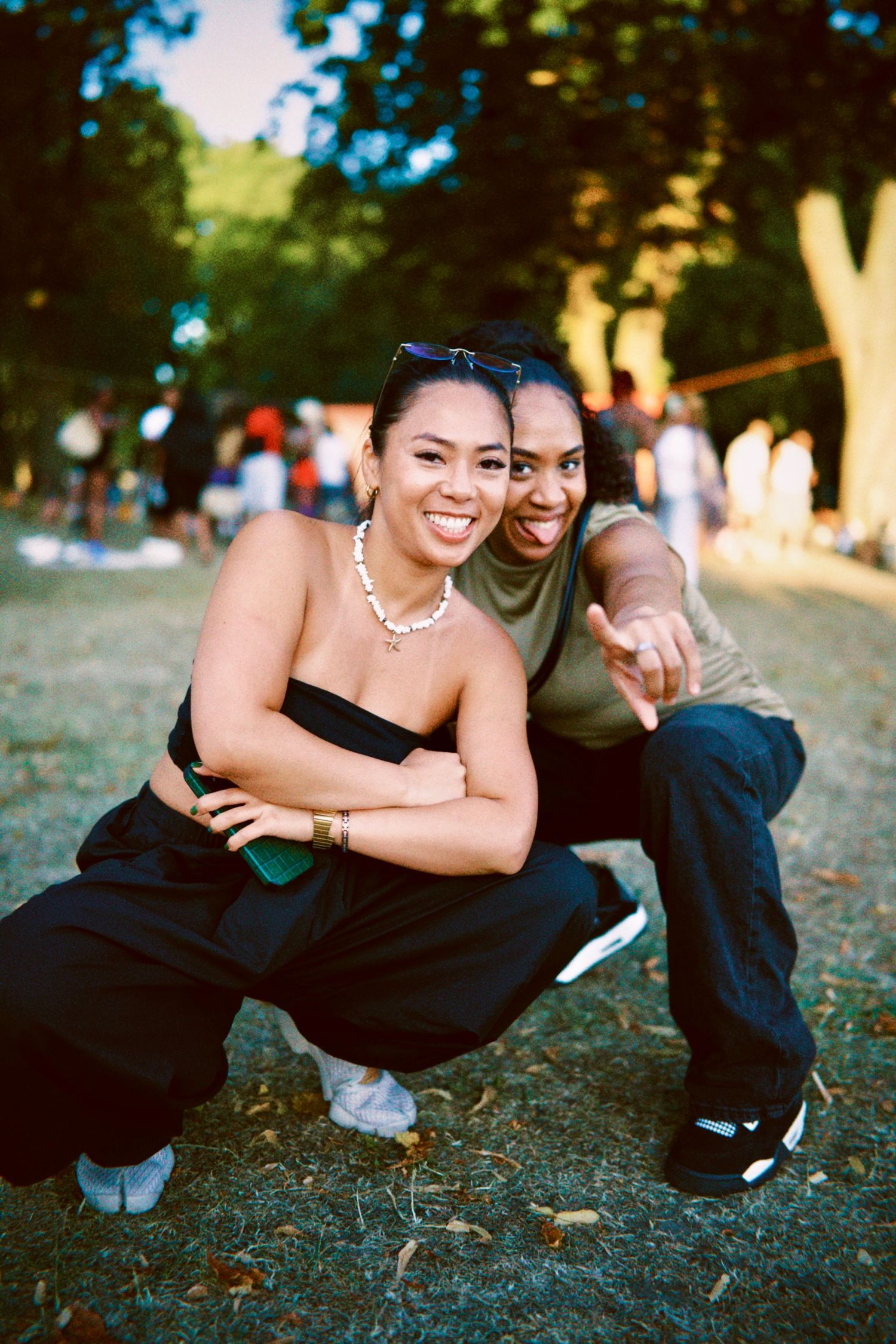 Man and woman smiling and posing on grass at outdoor London summer event by ARIETA Studios.