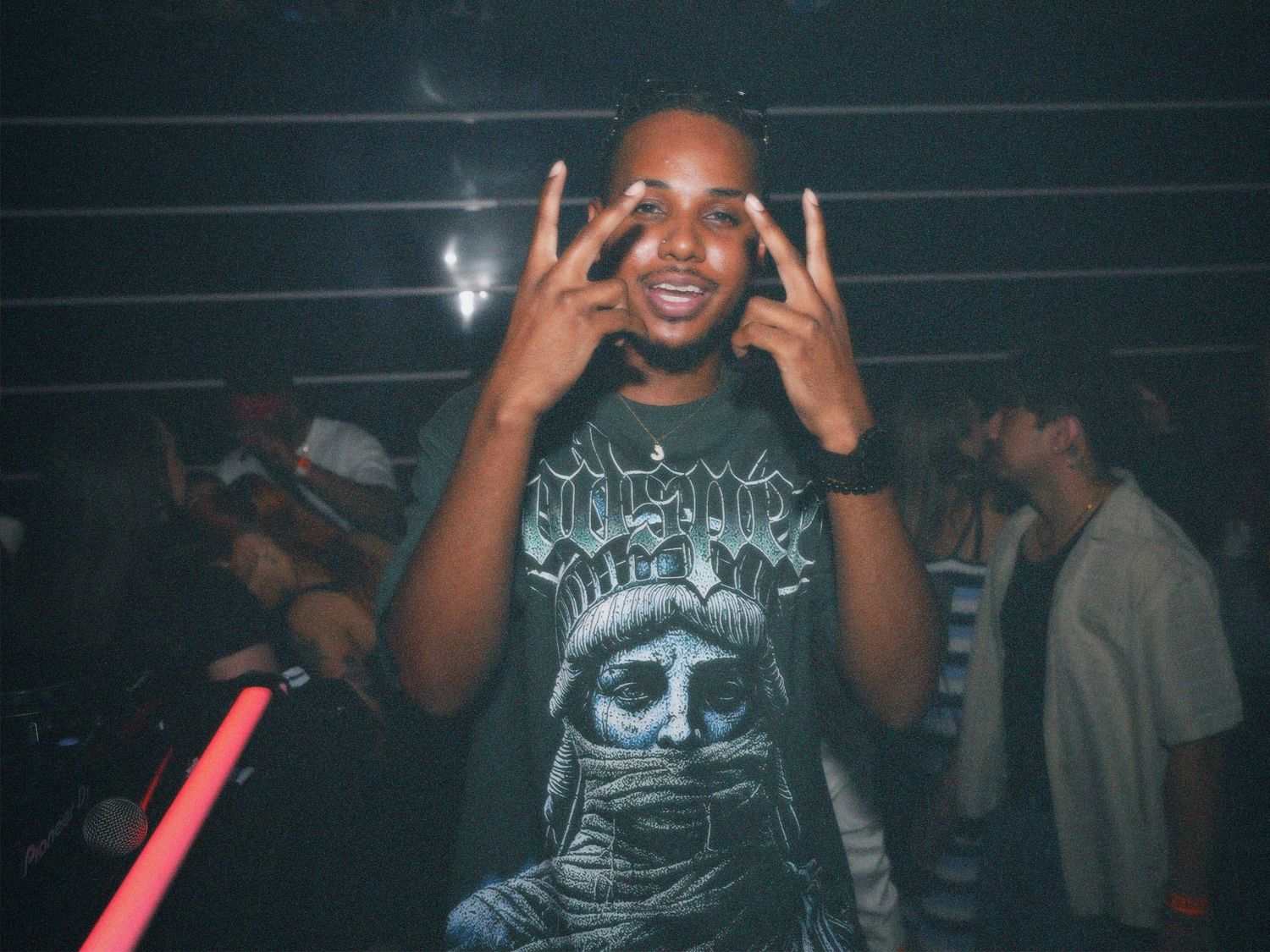 Man throwing peace signs on the dancefloor at Paradise Super Club event by ARIETA Studios.