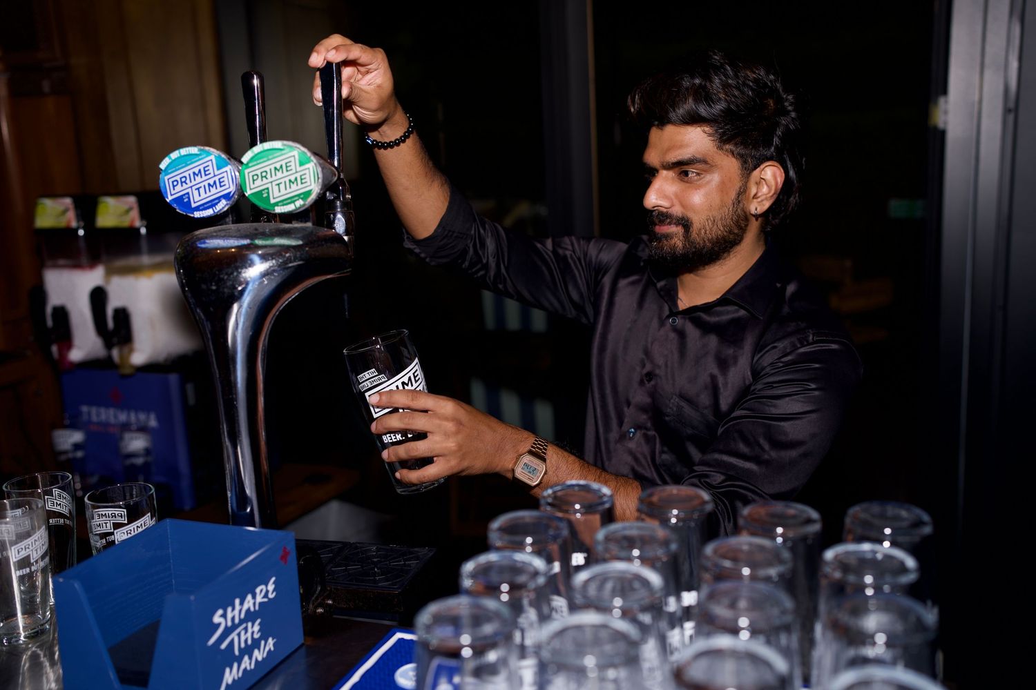 A bartender pouring a fresh pint of beer from the tap at a London brand activation after-party. Photo by ARIETA Studios.