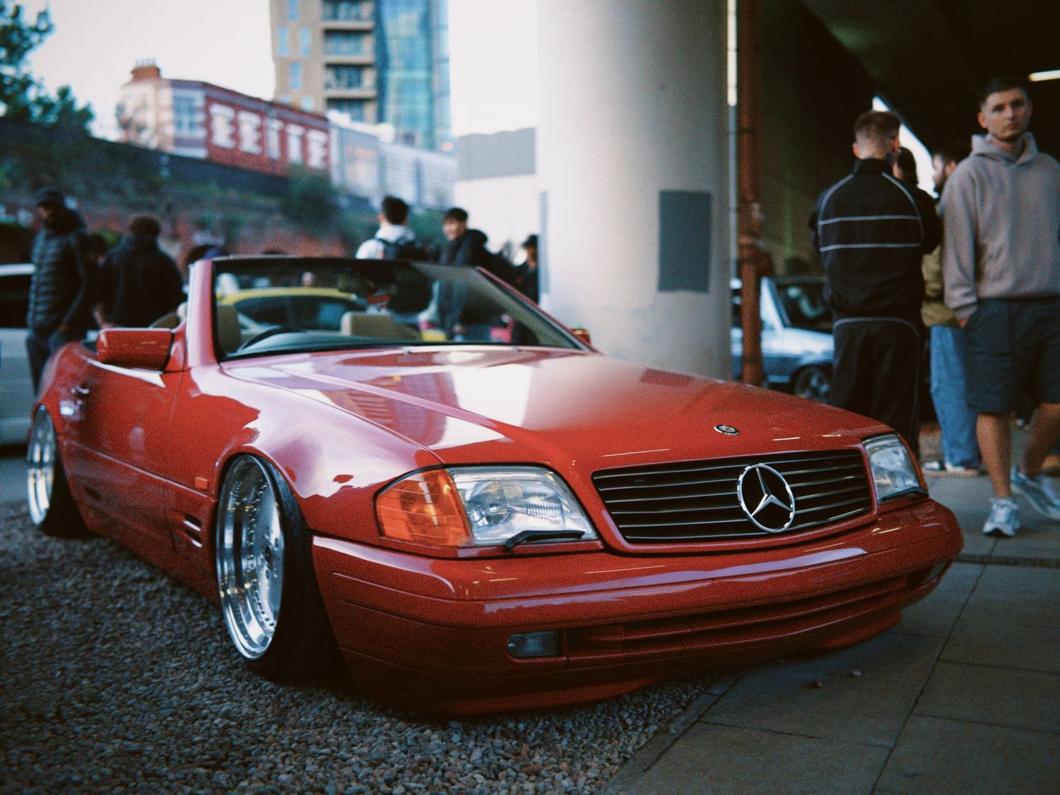 Stanced classic red Mercedes-Benz SL convertible parked at a London car meet.