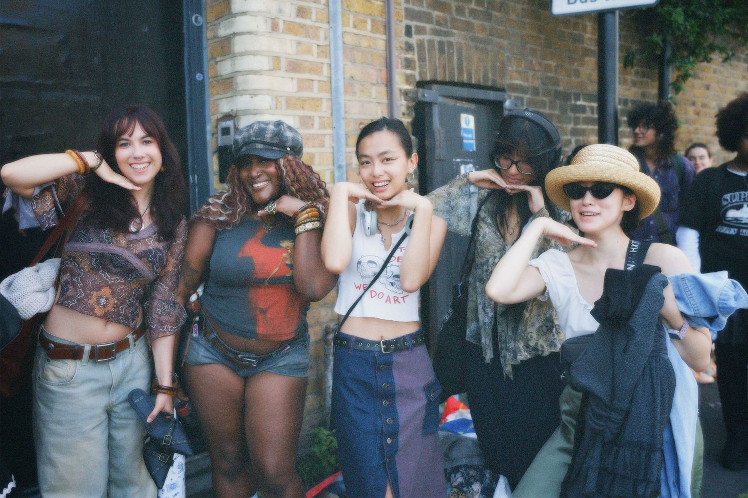 Group of four friends posing playfully in stylish y2k-inspired outfits outside the Hackney fashion event venue