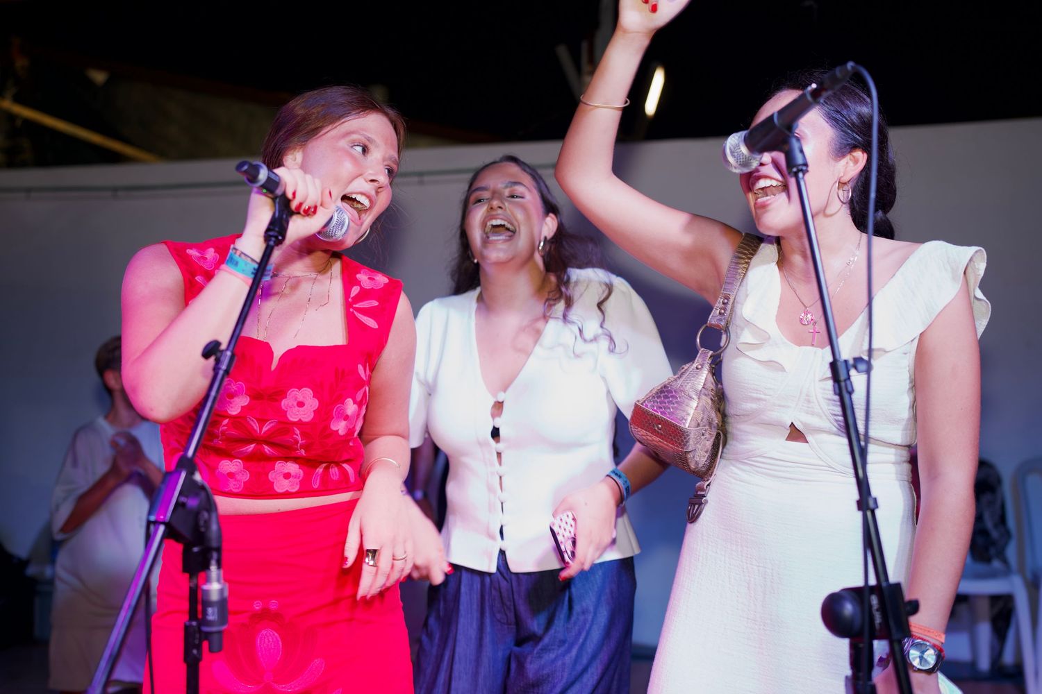 Three women singing on stage at Feria / Tres mujeres cantando en el escenario del Real.