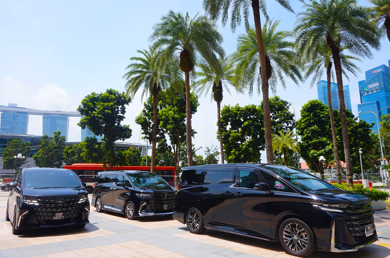 Luxury black vans parked outside by tropical palm trees, captured by London commercial lifestyle photographer ARIETA Studios.