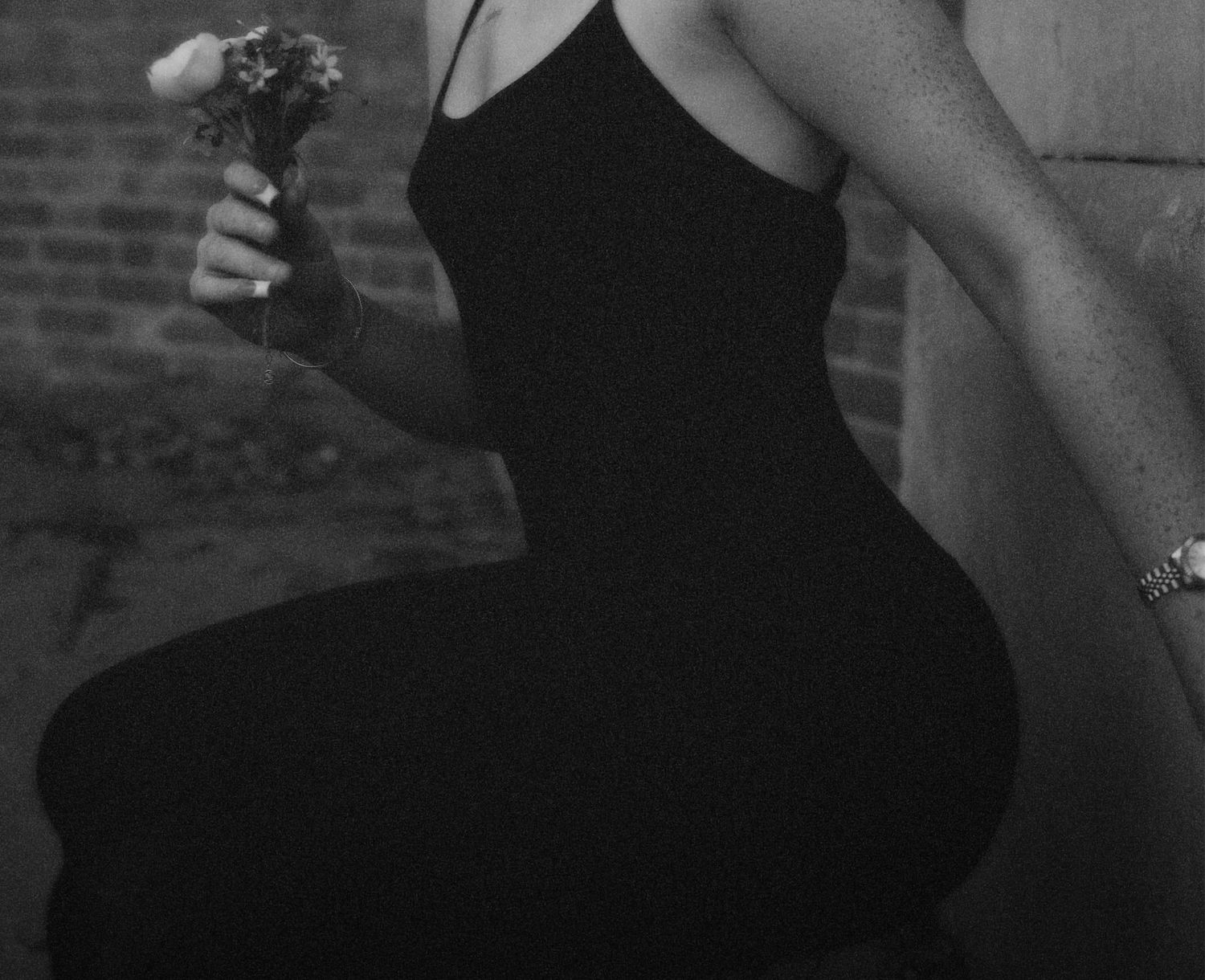 Black-and-white side profile of a woman seated holding a bouquet.