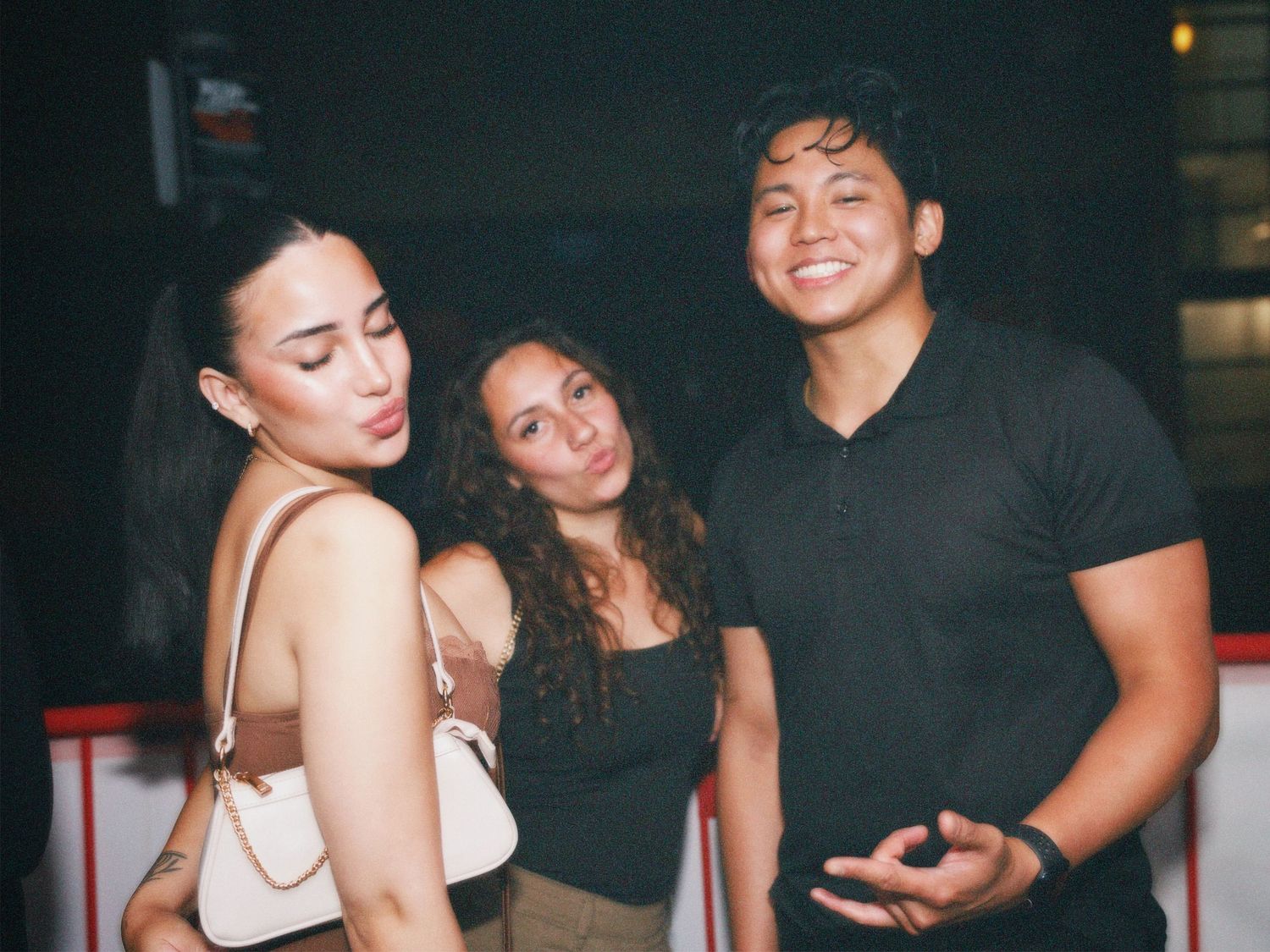 Group of three friends posing together at London nightlife event by ARIETA Studios.