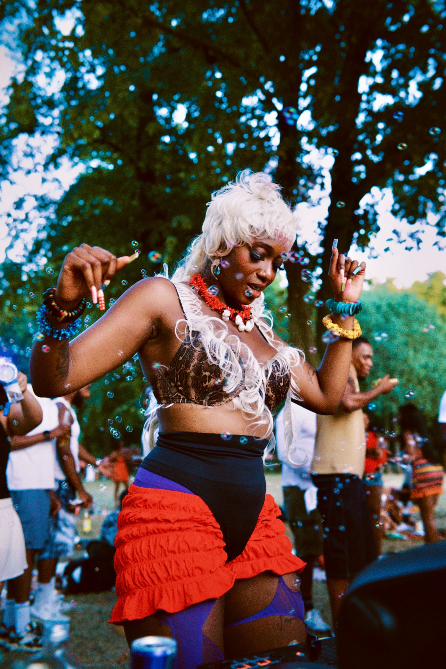 DJ TGMT, a beautiful woman dancing amidst bubbles at Mango Beats Golden Heat outdoor summer event by ARIETA Studios.