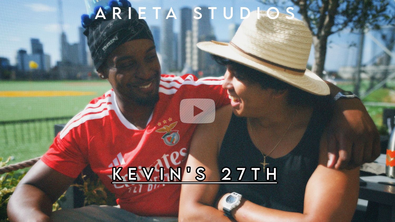 Candid outdoor portrait of two friends, Alastair and Kevin laughing together in summer hats during golden hour.