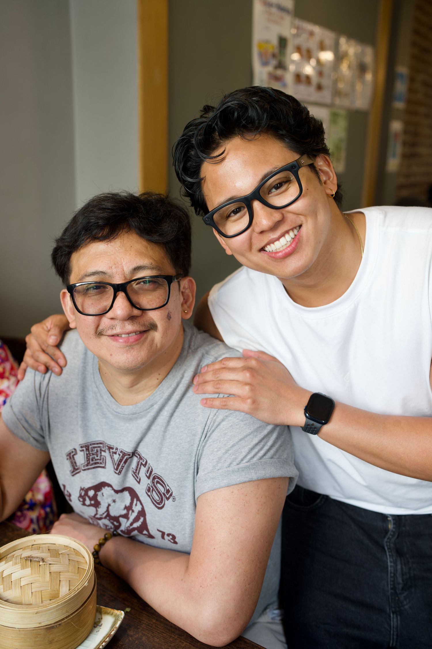 Two side-by-side candid portraits of a family sharing affectionate moments and smiling inside an authentic restaurant.