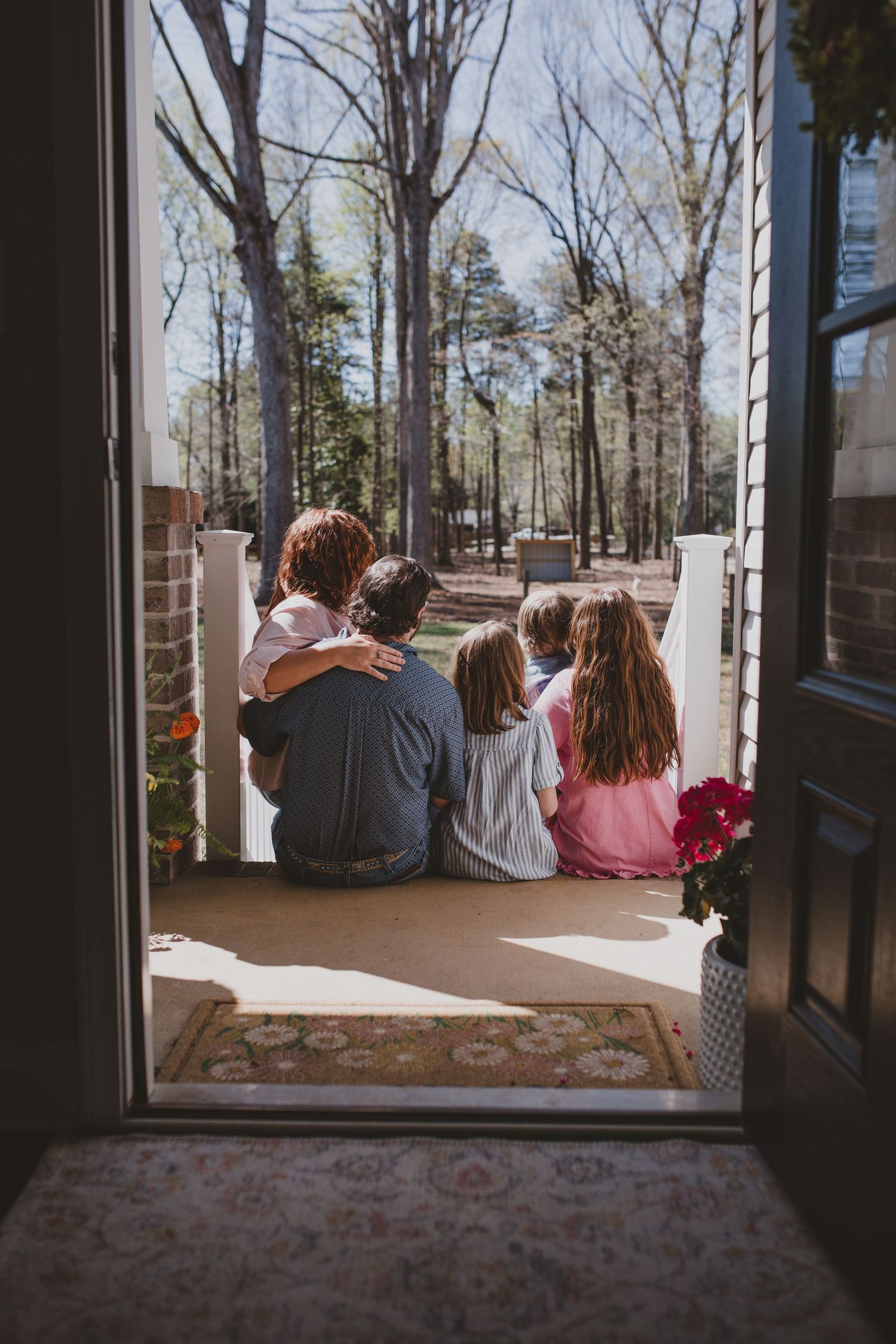Mother and her family sitting together in a doorway, representing the family, faith, and inspiration behind KD Kreative Digital’s story.
