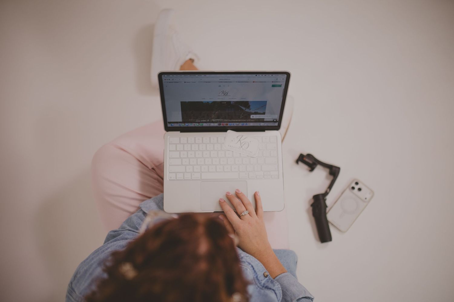 Content creator planning and editing social media content for weddings, photographers, and small businesses using a laptop and smartphone.