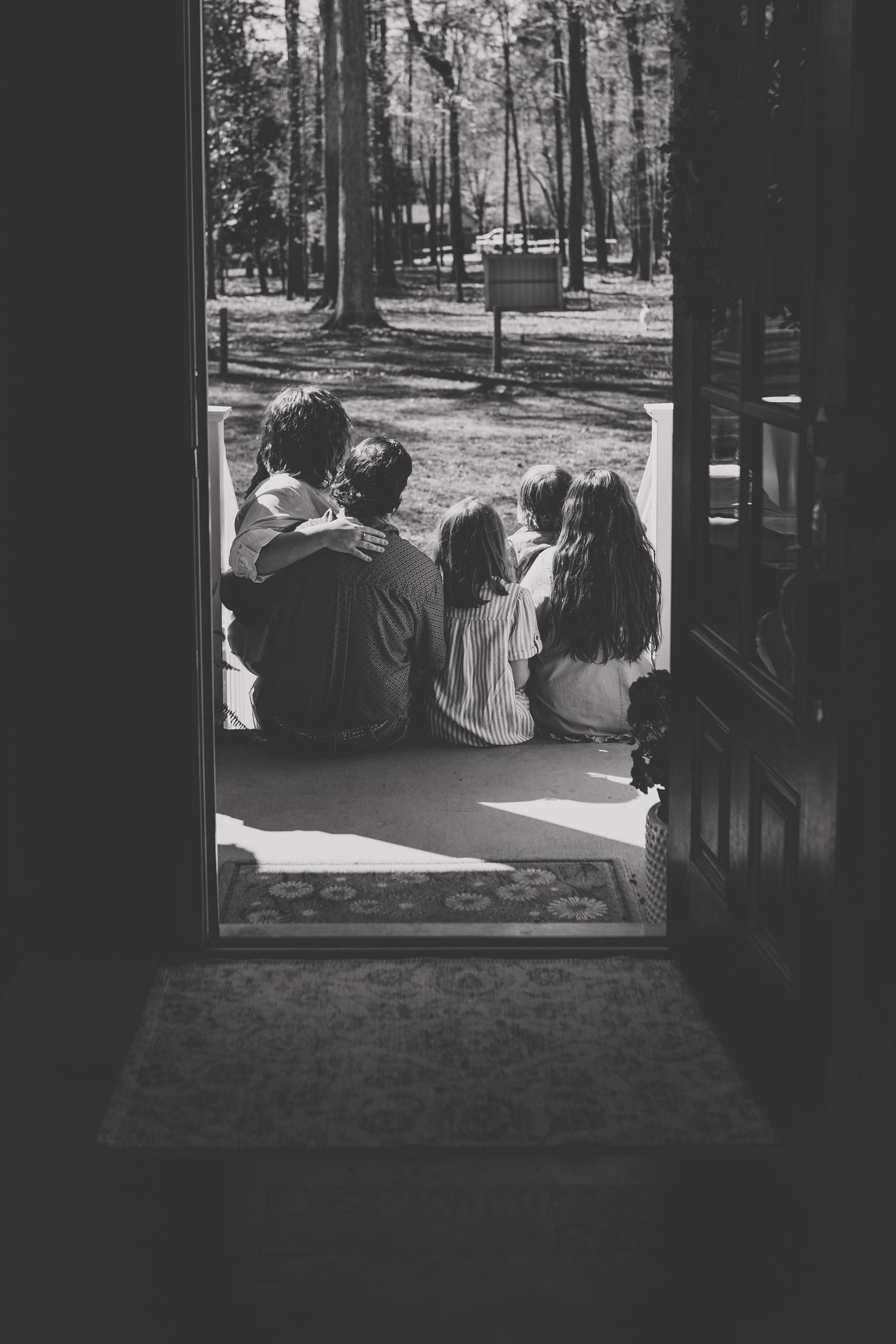 Mother and her children sitting together in a doorway, representing the family, faith, and inspiration behind KD Kreative Digital’s story.