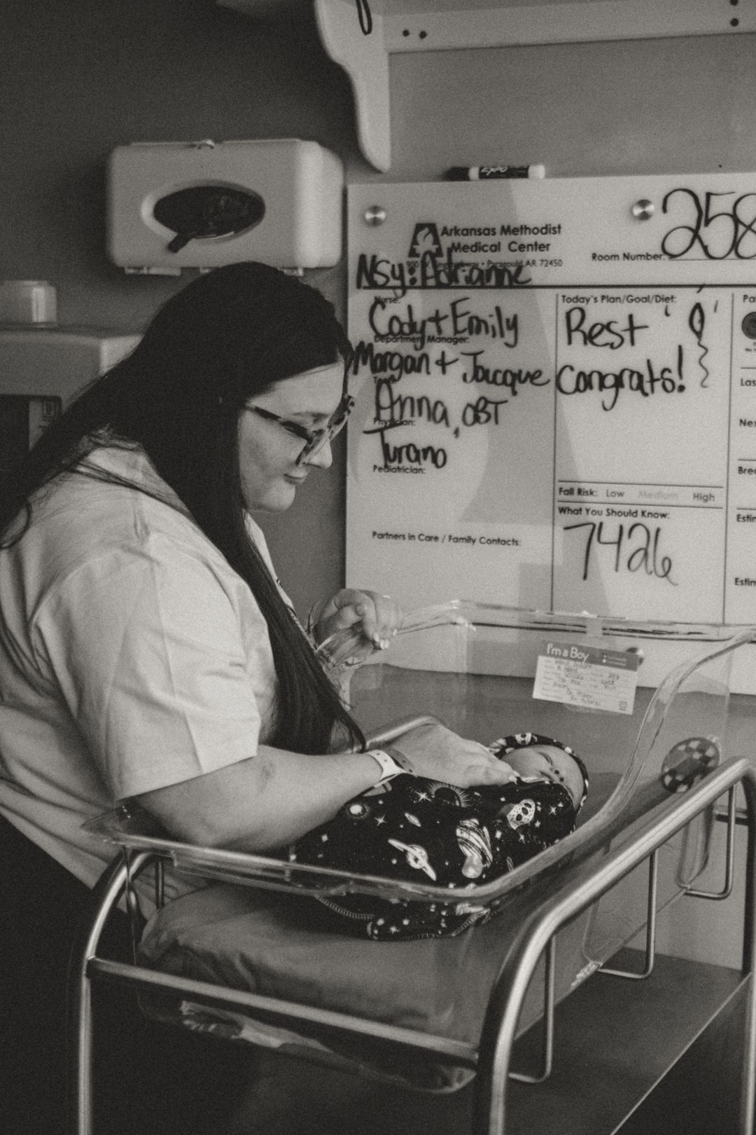 Black and white photo of a new mother holding her newborn in a hospital room at Arkansas Methodist Medical Center.