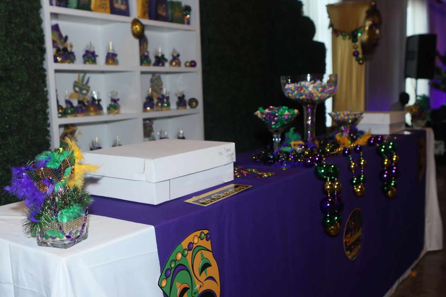 Mardi Gras themed table display with purple cloth, beads, masks, and decorations.