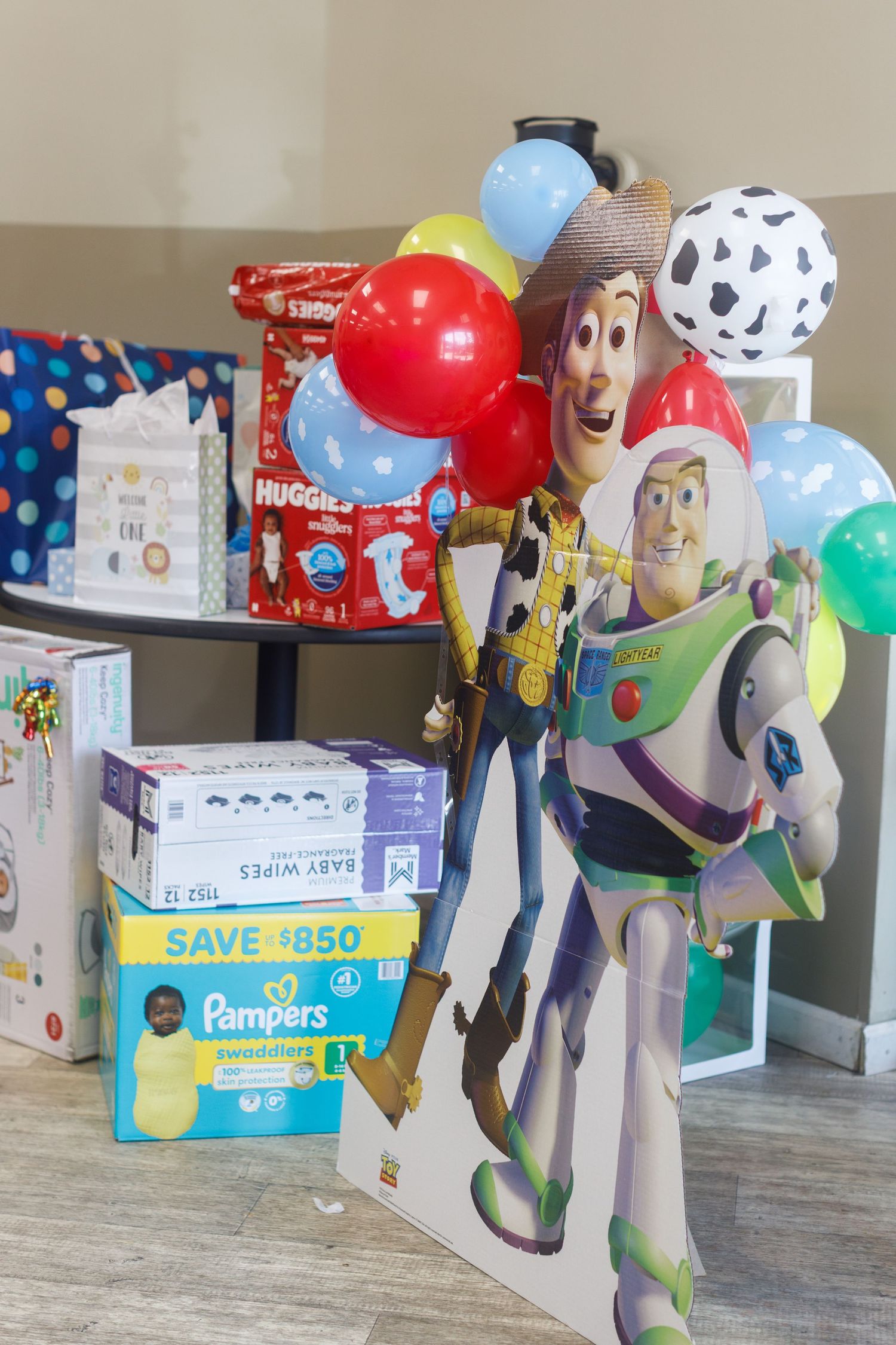 Toy Story Woody and Buzz Lightyear cutout with balloons and Pampers diapers display.
