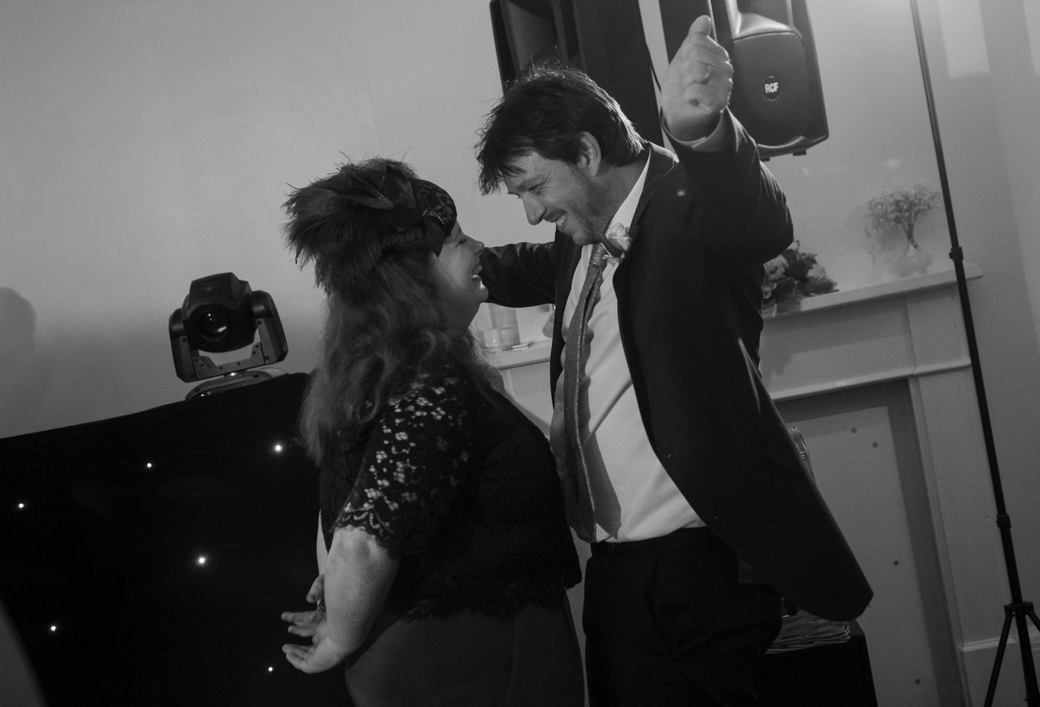 Black and white photo of couple dancing together at a wedding reception celebration.