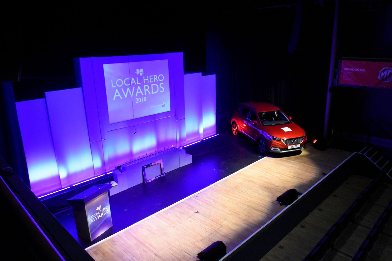Aerial view of Local Hero Awards stage with an Orange Range Rover. Evoke and blue lighting.